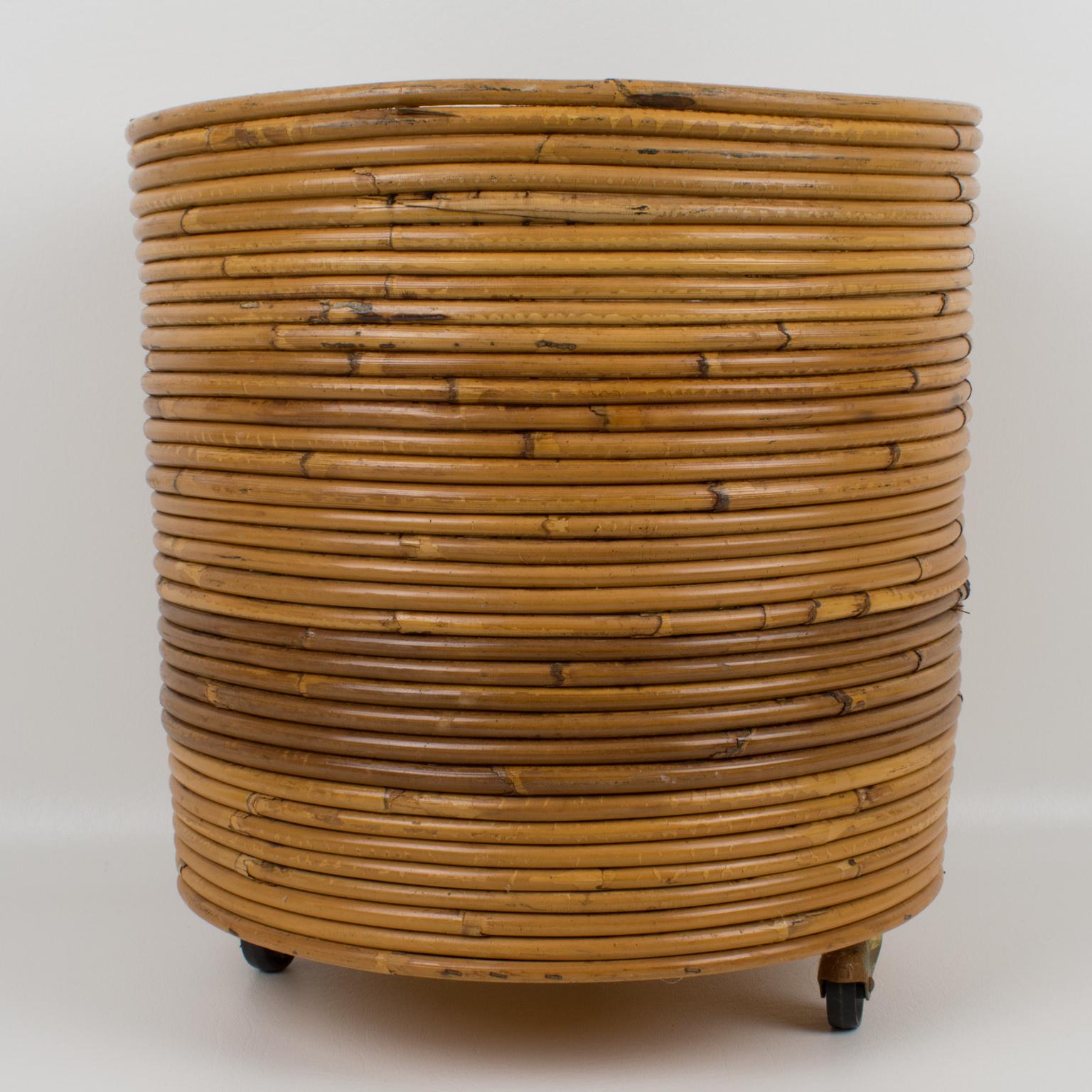 Lovely pencil reed rattan or bamboo large planter. The rounded shape is on three wheels. Marked underside: 