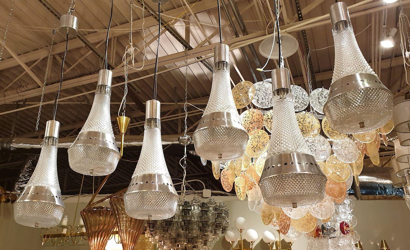 Conjunto de tres pares de lámparas de araña colgantes italianas, modernas de mediados de siglo, hacia la década de 1970.
Las seis lámparas colgantes vintage están hechas de cristal transparente en forma de diamante y acero cepillado.
Los colgantes