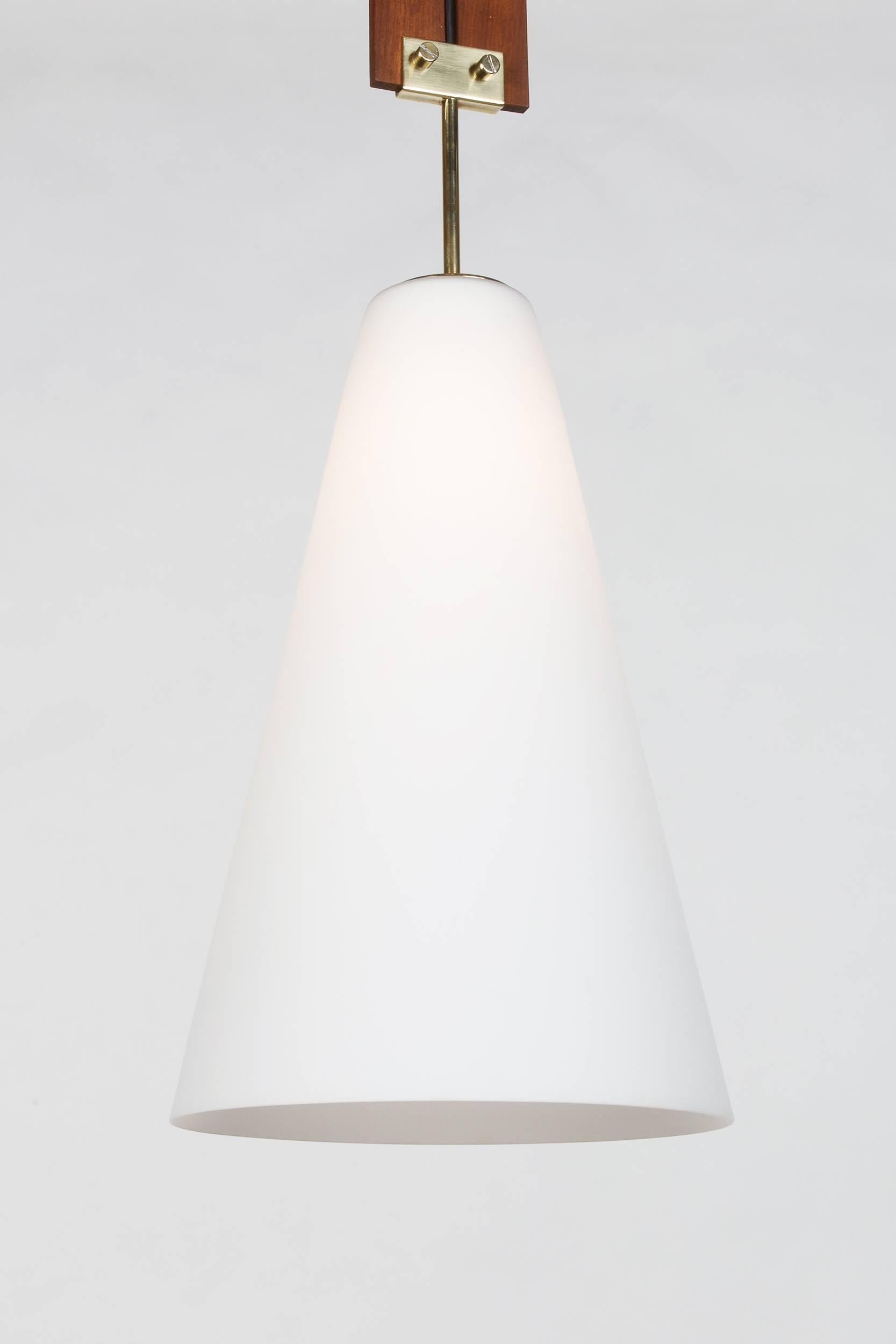 Italian pendant mounted on two mahogany rails, small series production of the 1960s. Cone-shaped shade made of opaline glass, beautiful brass details. This small shaped pendant is perfect above a dining table or in an entrance with high ceiling.