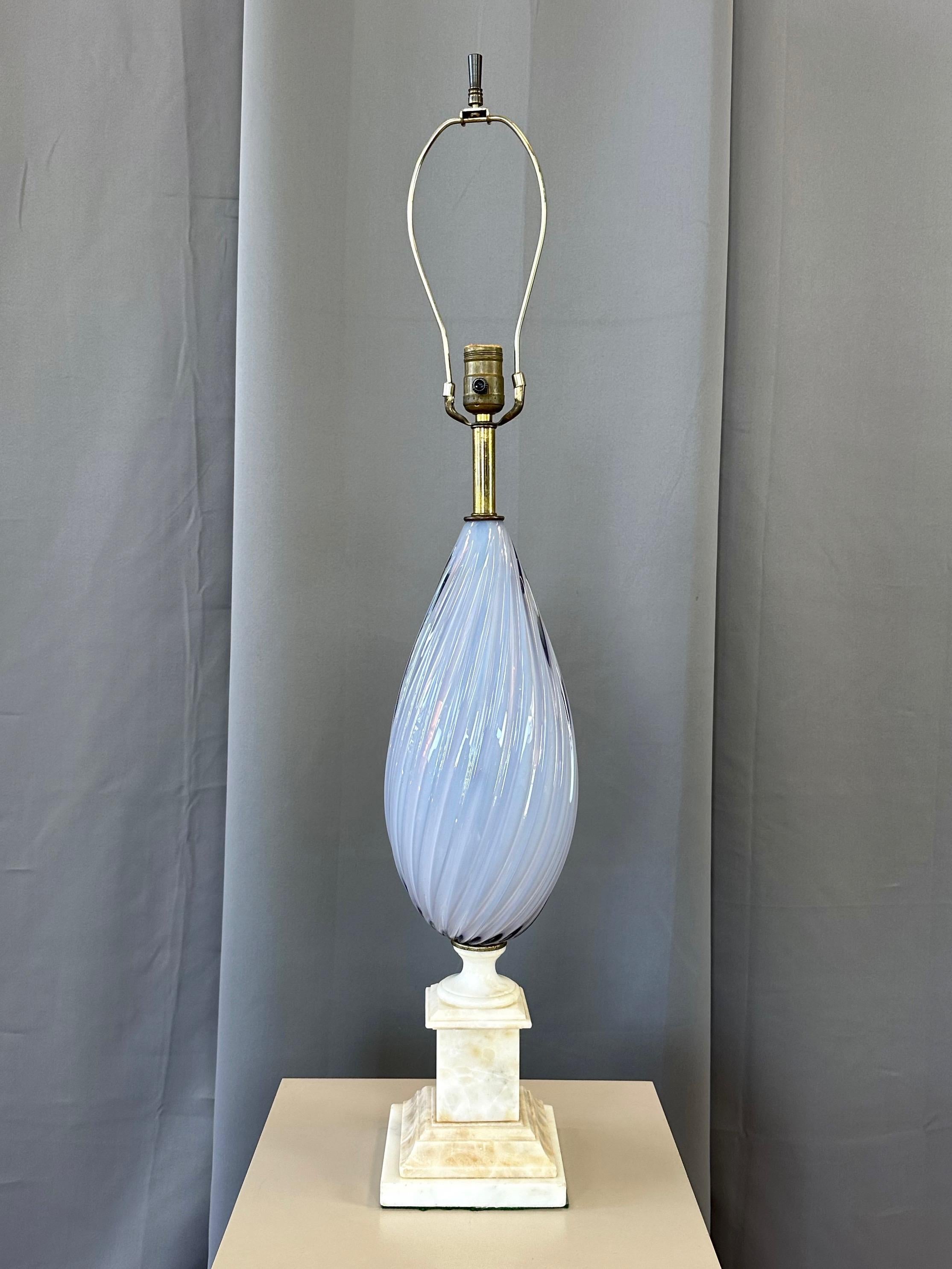 A gorgeous circa 1950 Italian periwinkle sommerso Murano glass table lamp on alabaster base.

Elegant hand-blown glass twisted tear drop-shaped body in an absolutely beautiful shade of pale periwinkle encased within a thin clear layer. A skillfully