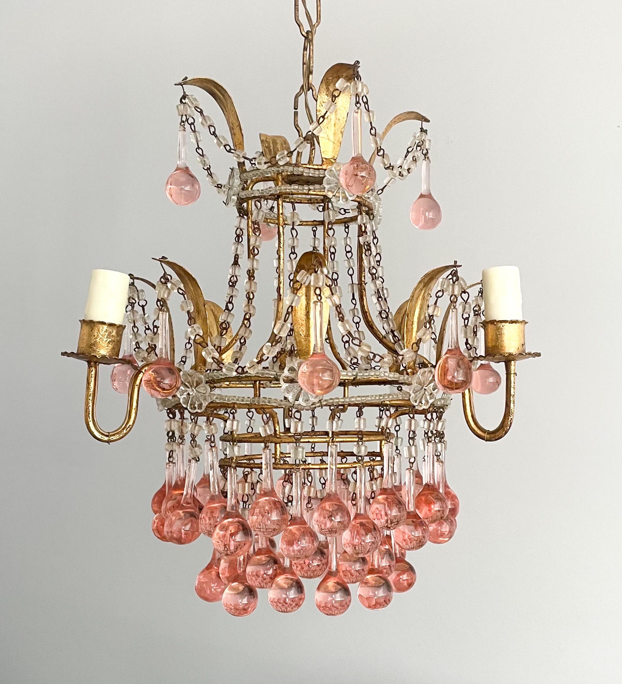 Rare and beautiful, Italian vintage gilt-iron and crystal beaded chandelier.

The chandelier consists of a petite-scale gilded iron frame with an abundance of bulbous pink Murano glass drops.

The chandelier is wired and in working condition, it