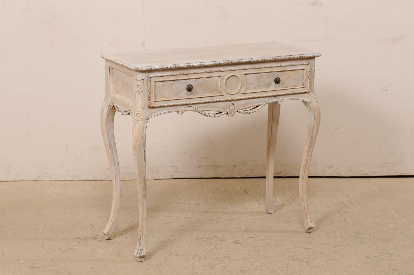 An Italian petite sized console table with single drawer from the mid 20th century. This vintage side table from Italy features a rectangular-shaped top with nicely carved and curved edges, which rests atop an apron which houses a single and