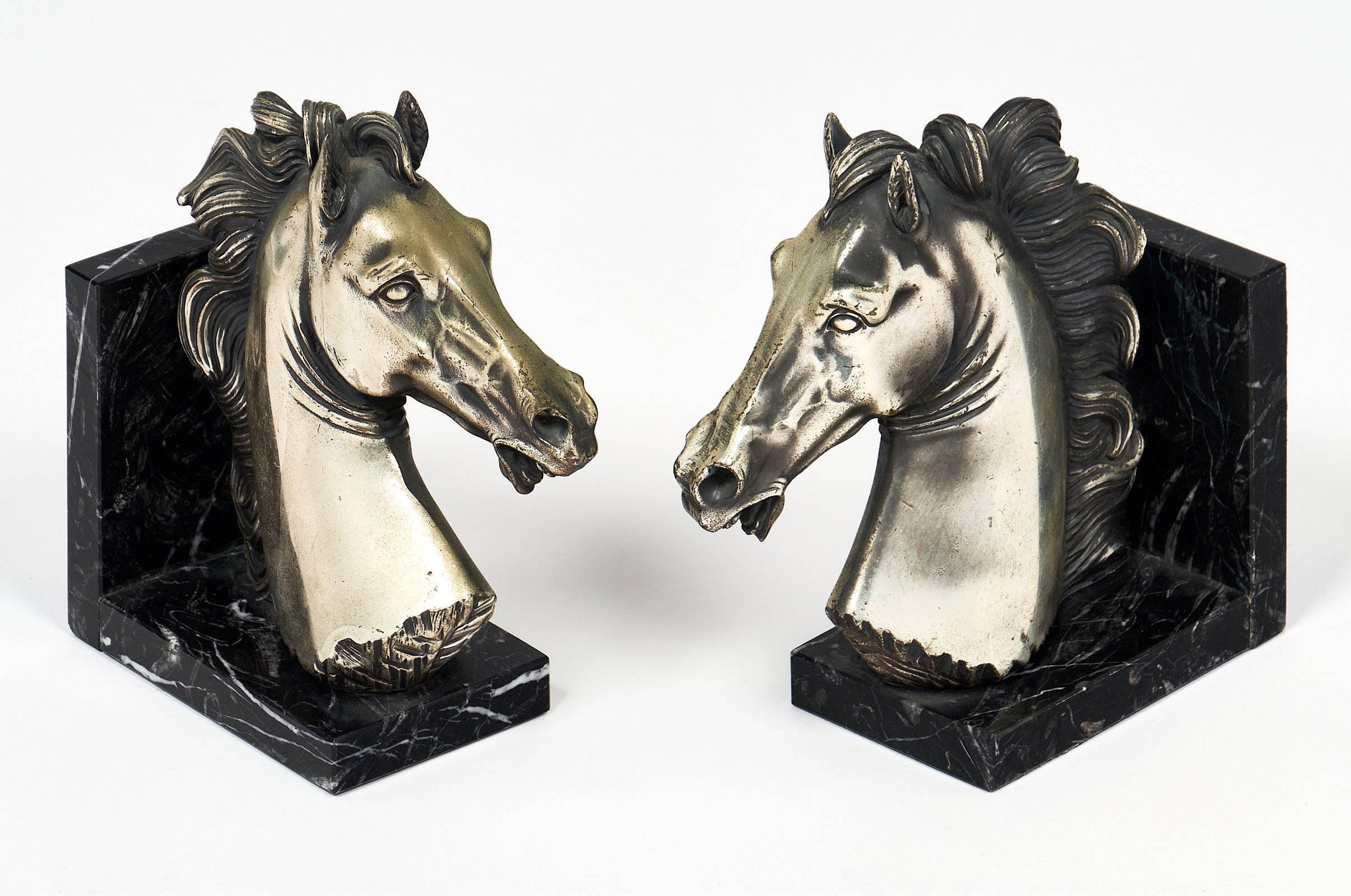 A pair of finely cast pewter Italian horse head bookends mounted on Portor marble bases. The styling of the book ends are highly reminiscent of the Leonardo da Vinci Italian Renaissance horse head.