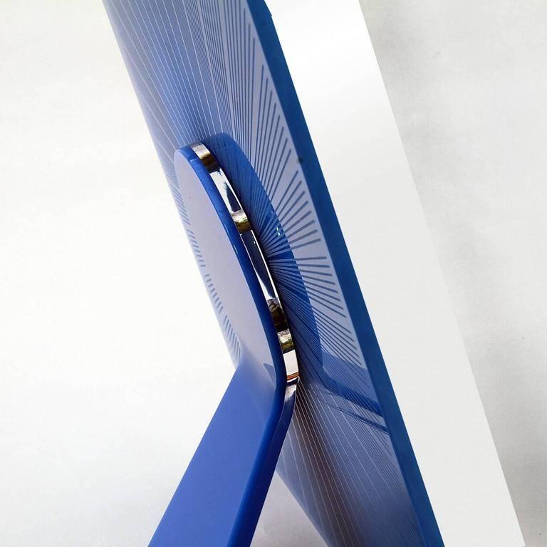 Sharing blue is a square Italian pop design picture frame in blue plexiglass of Art with Heart collection of photo frames by Laura G ,Italy. It is realized into plexiglass royal blue and white, with guillochè rays handworked into blue plexiglass