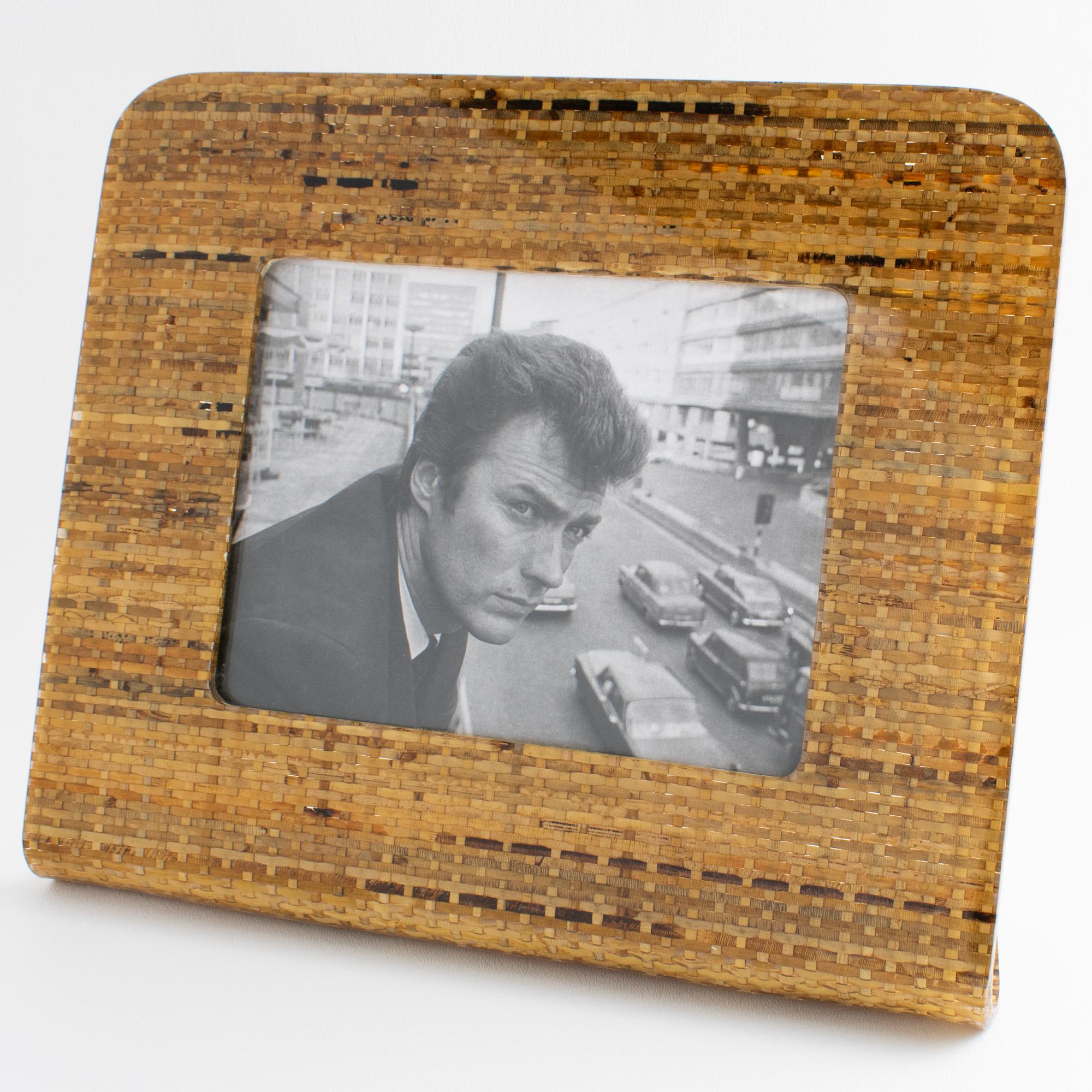 This stunning modernist Lucite and rattan picture frame was expertly crafted in Italy, circa 1970. This exceptional decorative piece boasts an 