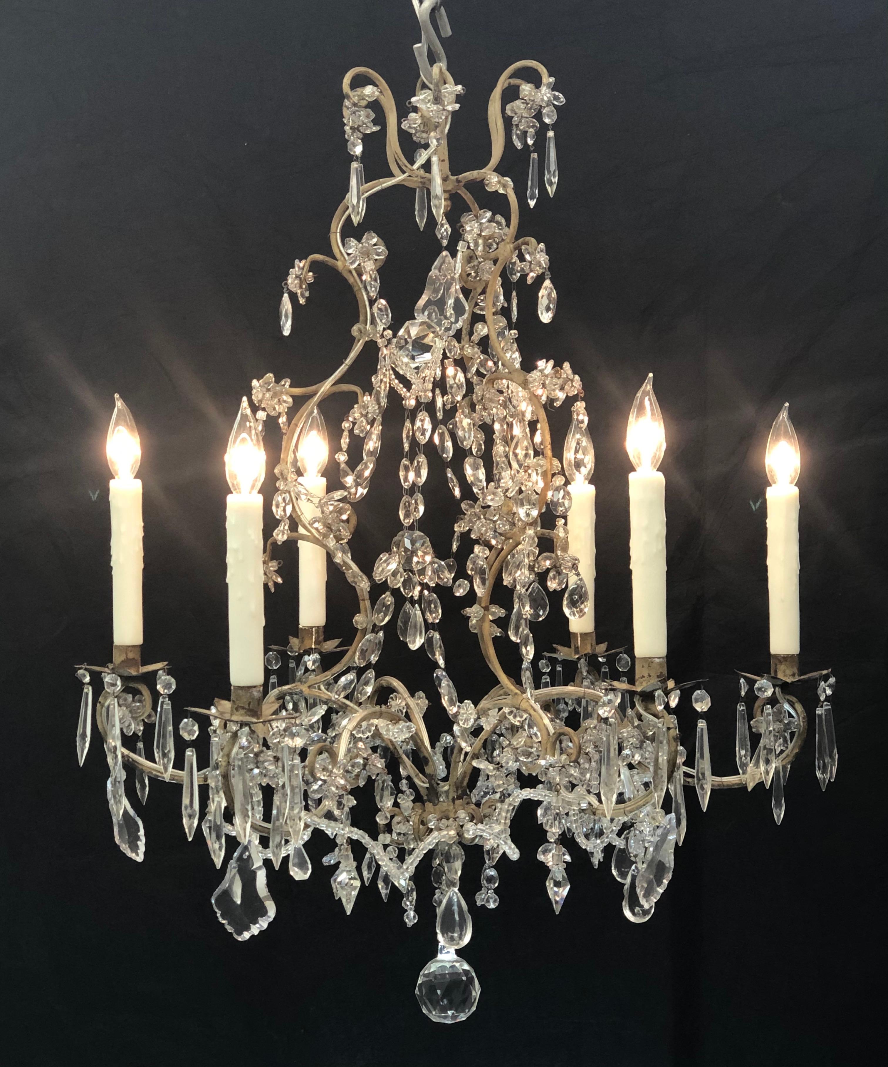 This Elegant Piedmont chandelier is in a Whimsical Chinoiserie Style. The early 19th century Orientalism styled chandelier was originally candle. The chandelier has a Tôle frame with six candle arm branches all decorated in fine hand cut crystal.