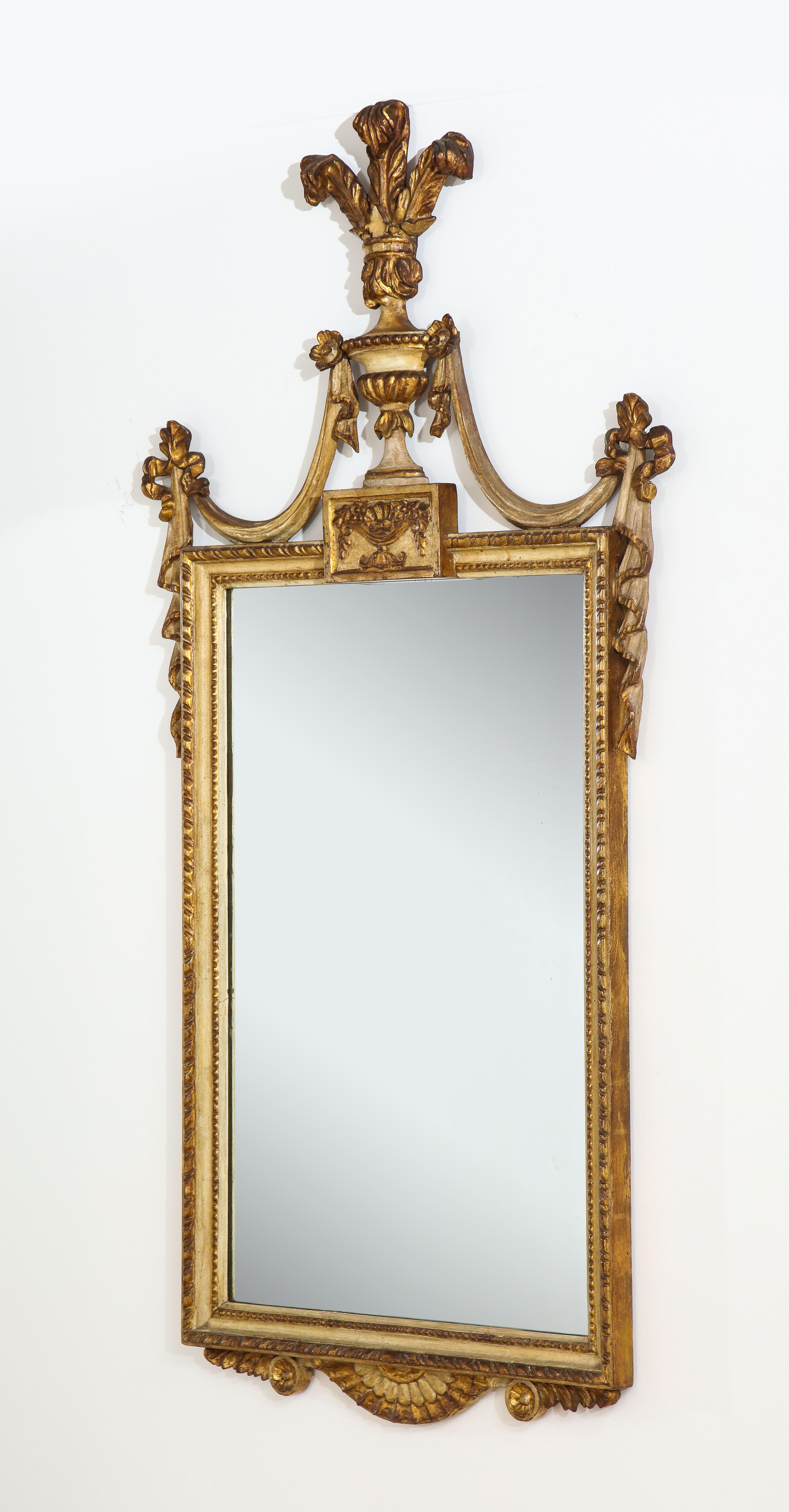 A beautifully carved Italian Piedmontese neoclassical Louis XVI giltwood and painted mirror. The original rectangular mirror plate is framed within a finely carved giltwood border with a lovely beaded design. The crest surmounted by a rectangular