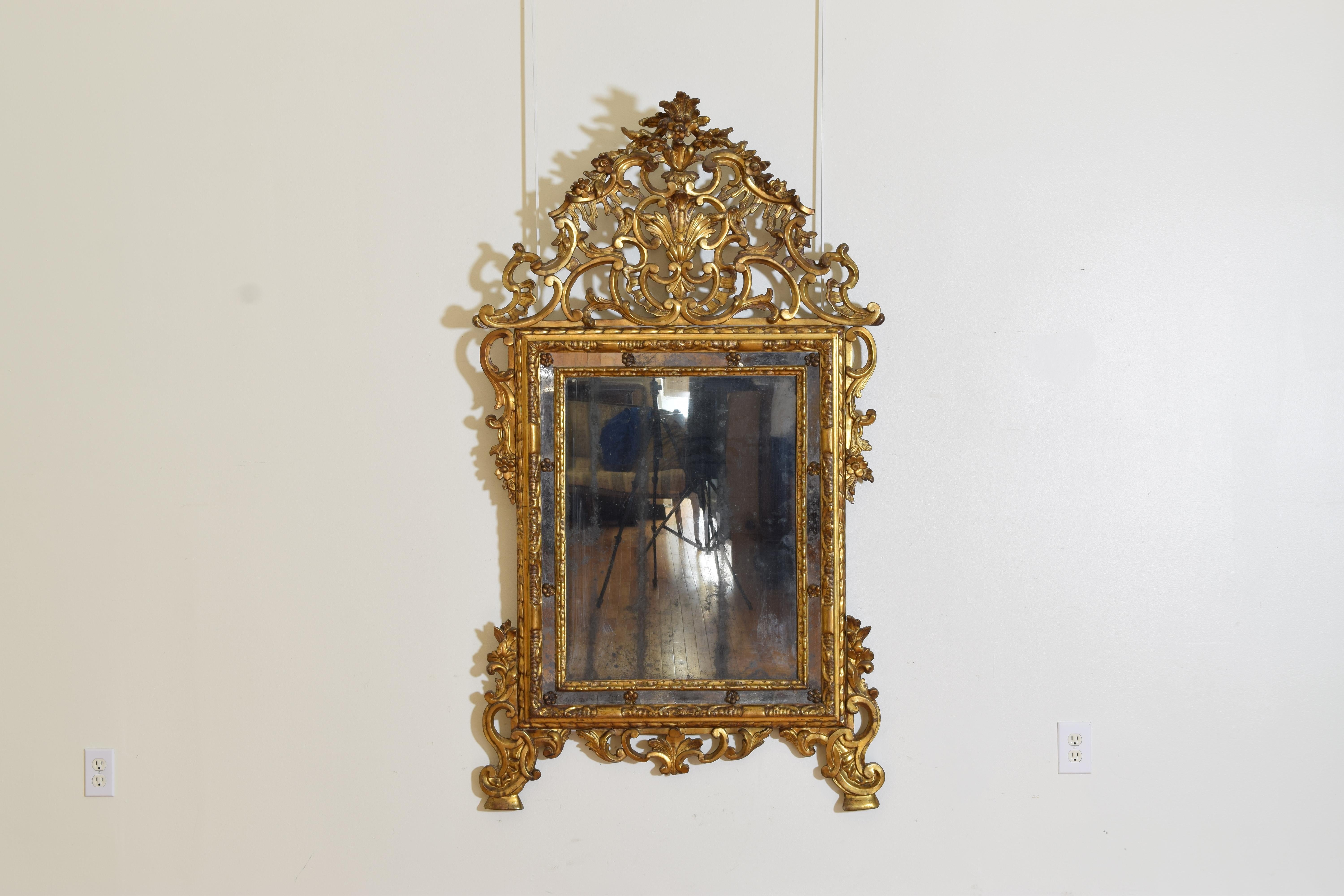 Of ornate design this mirror is in a fantastic state of preservation and features an inner rectangular frame with a series of moldings and the outer mirrored surface punctuated by giltwood rosettes, the detachable upper section a masterpiece of