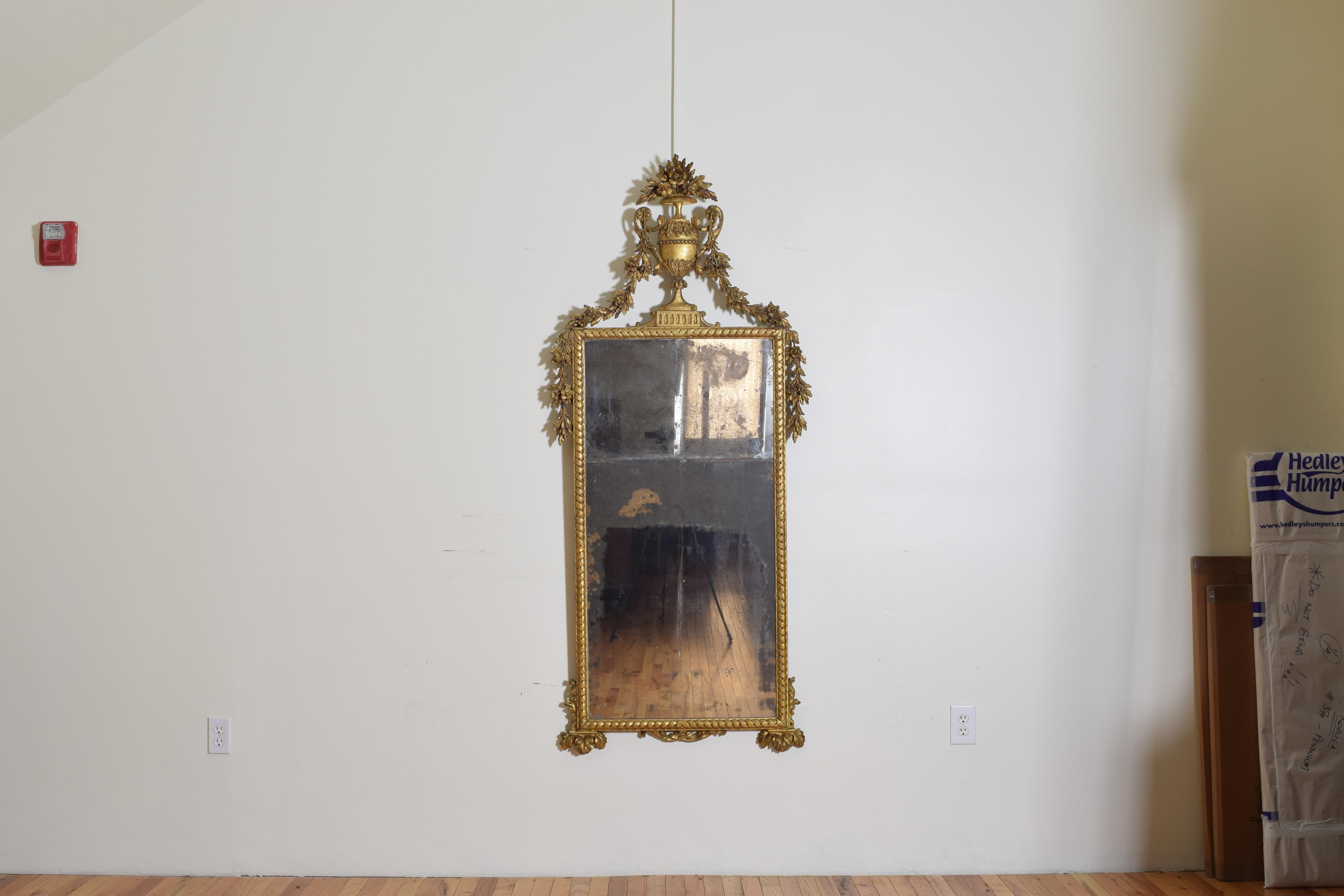 Beautifully carved, the urn as a finial showing great depth, with swags of garland at the top and sides, the rectangular frame carved in pattern, the bottom with carved 