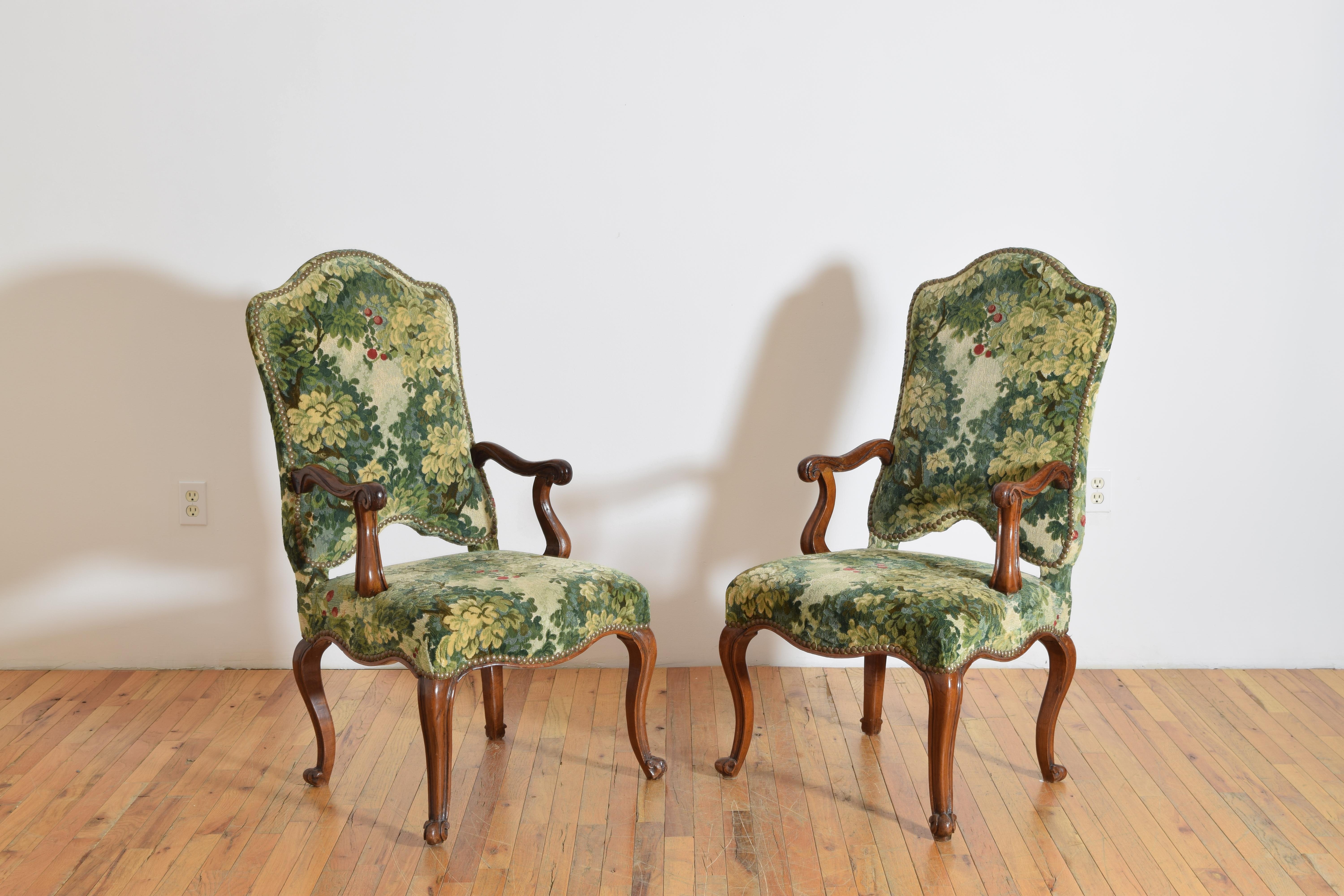 Les chaises ont des dossiers arqués et inclinés, des accoudoirs en forme et des sièges généreux reposant sur des pieds cabriole.