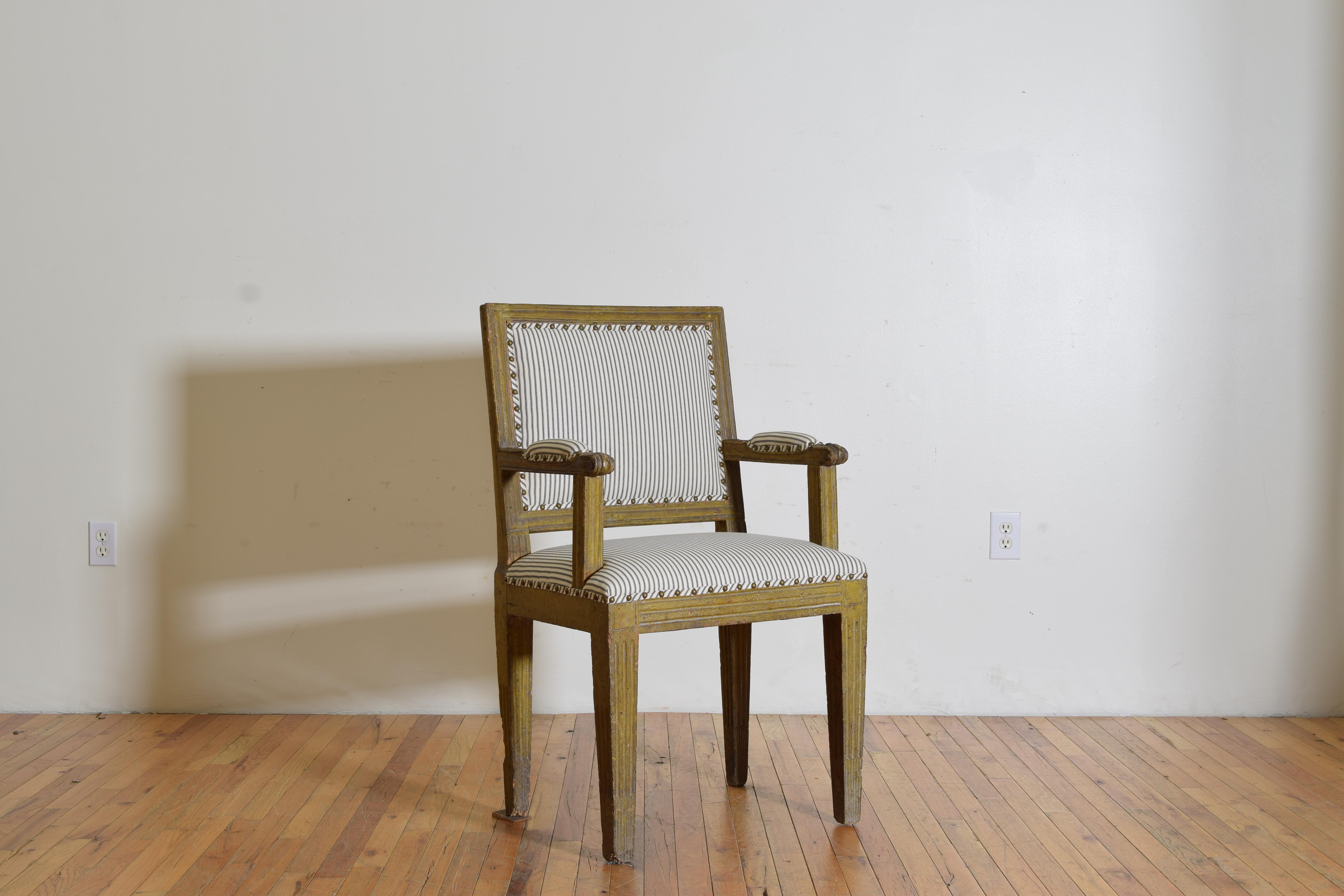 This unique chair has a square caned and upholstered back with carved moldings, straight arms with upholstered elbow pads, the tight seat above a square frame resting on square tapering legs with fluted carvings.