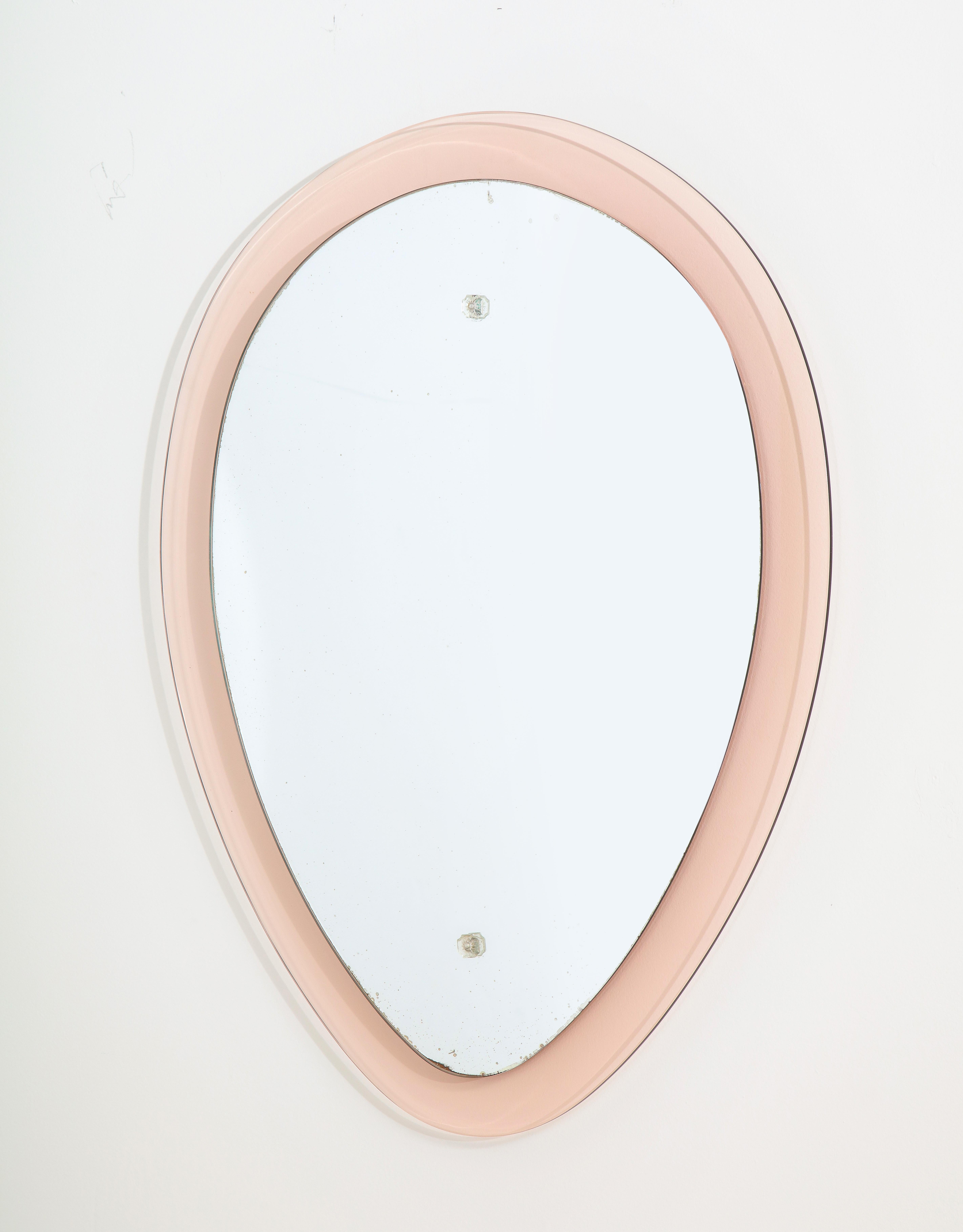 An Italian beautiful pale pink and clear glass mirror in the shape of a reverse teardrop. The oval mid-section is clear glass and is raised which gives a floating effect, the hardware on the clear glass is crystal. 
Italy, circa 1955
Size: 31 1/2