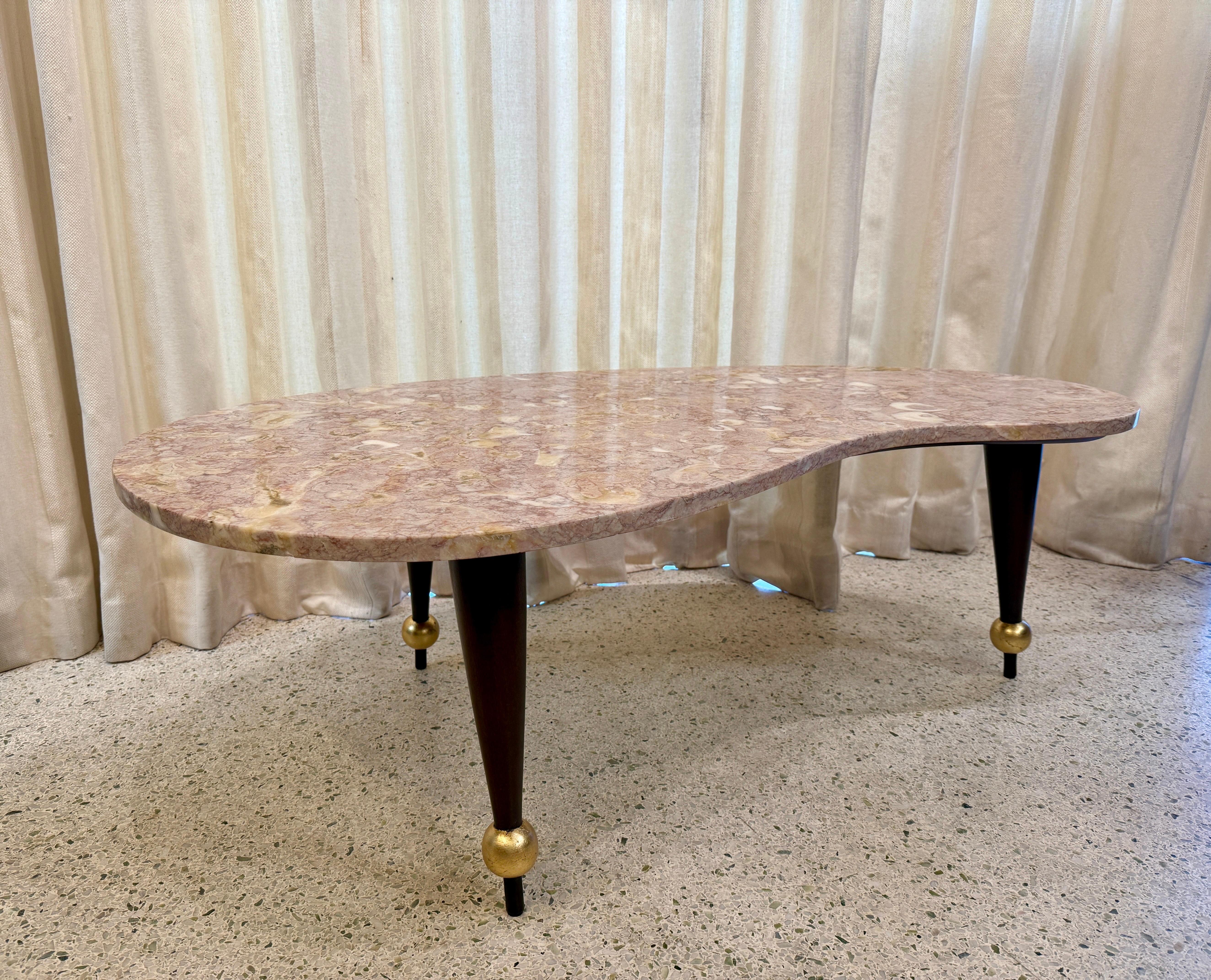 Doré Table basse italienne de forme amorphe en marbre rose sur base en bois en vente