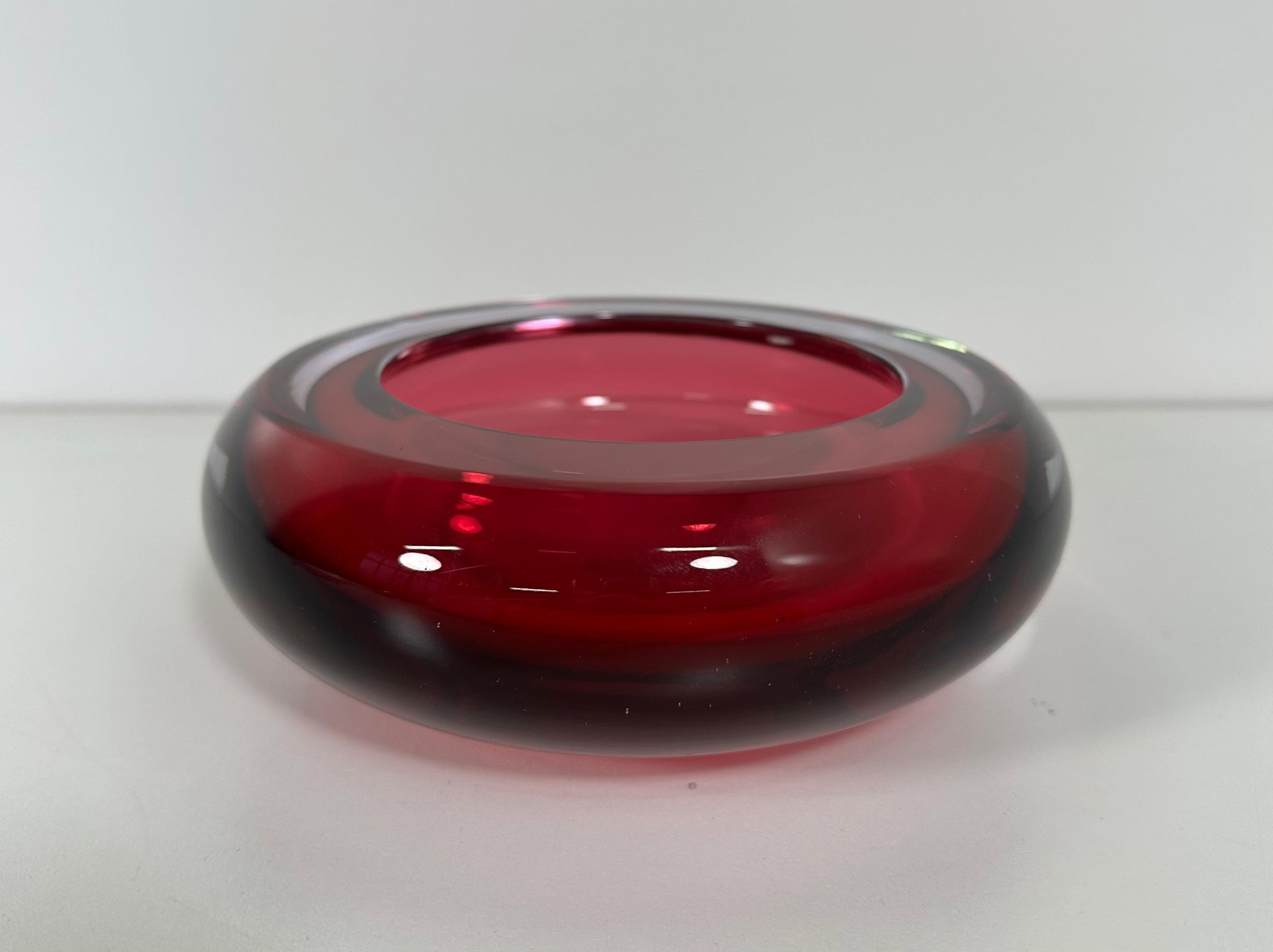 This fine and rare ashtray was produced in Murano, Italy in the 1950s and is attributable to Flavio Poli. 
It is made with a particular glass working technique called 'sommerso', which means made with different color layers: a pink one and a