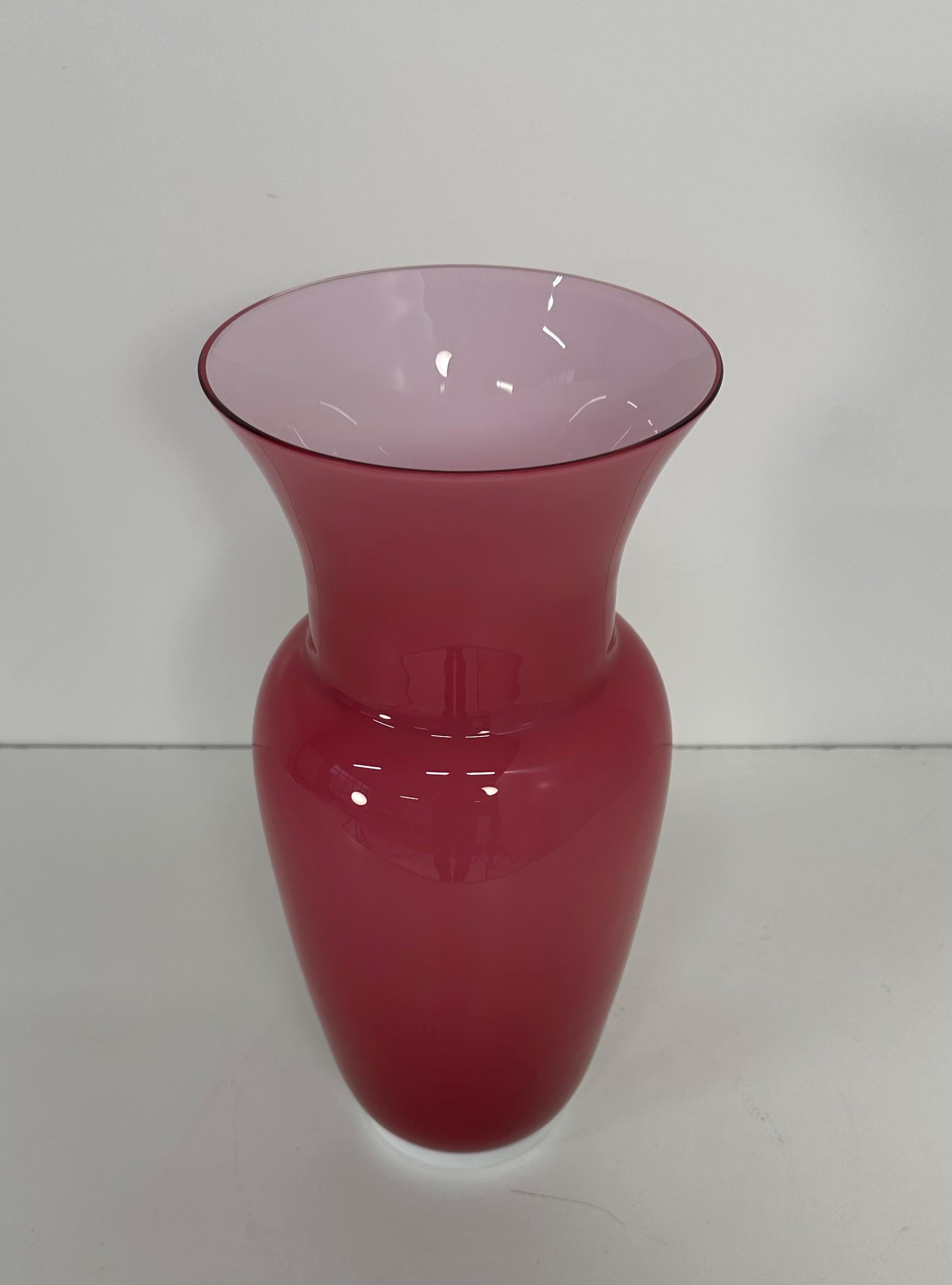 Diese Vase wurde in Italien, genauer gesagt in Murano, der Welthauptstadt der Glasherstellung, in den 1990er Jahren von Tommaso Buzzi für Venini hergestellt. Die Innenseite ist aus weißem Murano-Glas, die Außenseite ist rosa. 
Unter dem Sockel