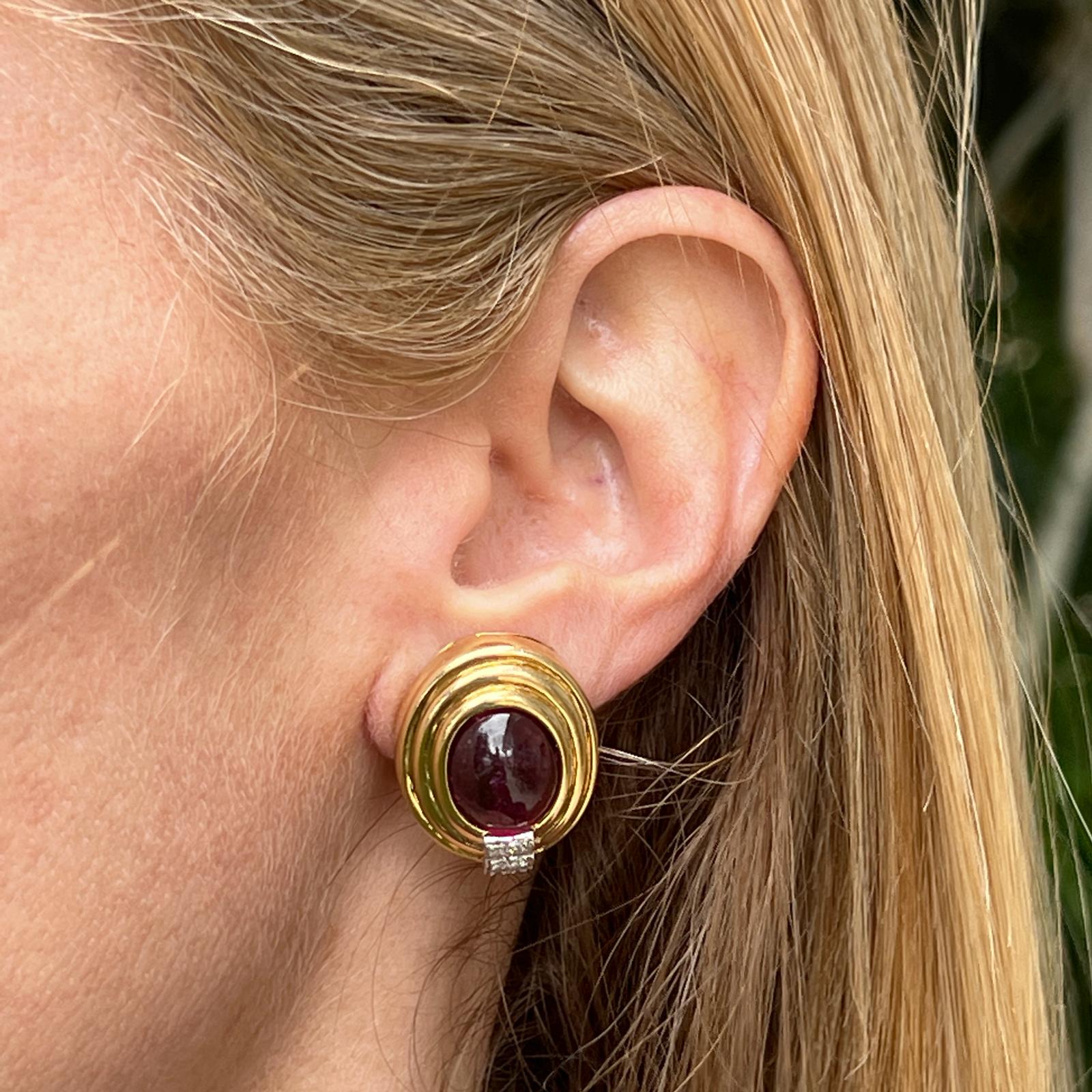 Italian pink tourmaline gemstone and diamond earrings crafted in 18 karat yellow gold. The earrings feature 2 oval cabochon pink tourmaline gemstones weighing approximately 10 carat total weight. The bezel set gemstones are surrounded by ribbed 18