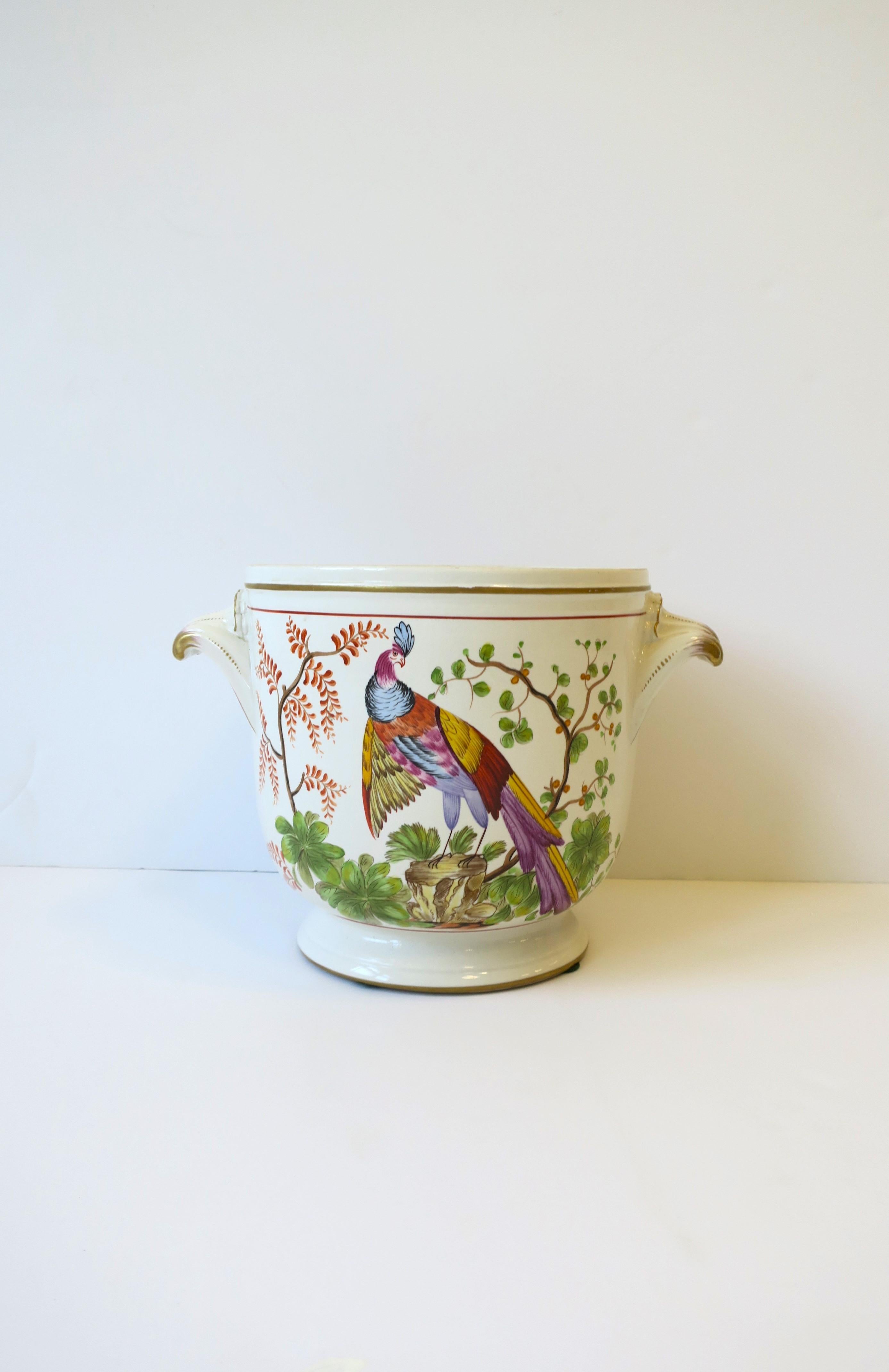 A beautiful Italian flower or plant potholder planter cachepot jardinière with peacock bird by Mottahedeh, circa mid-20th century, Italy. Pot is cream off-white ceramic with prominent colorful peacock bird on front, garden foliage on back, and