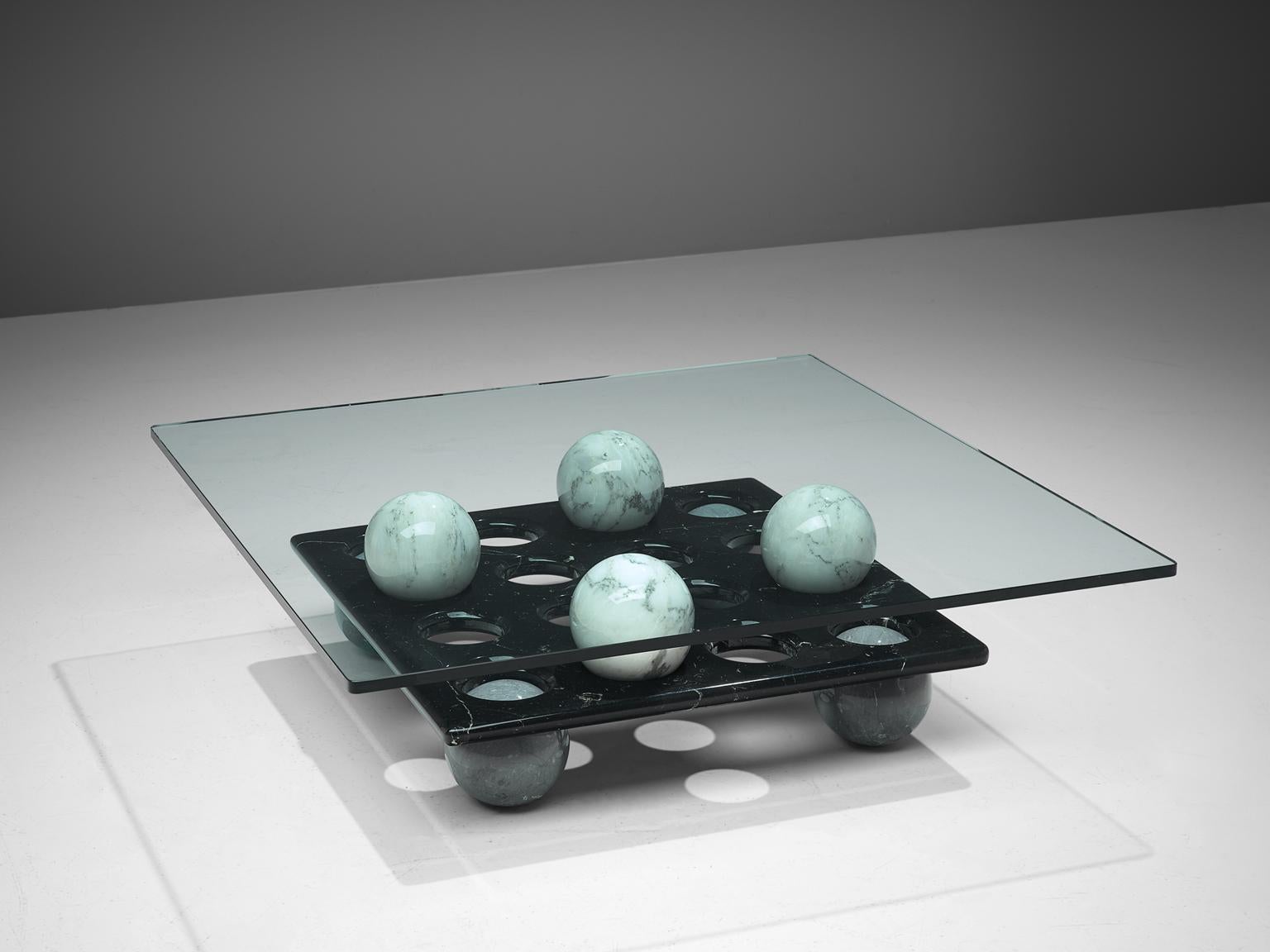 Cocktail table, glass and marble, Italy, 1970s.

This coffee table consists of two layers, divided by marble spheres. The op is made of glass, while the second layer is made of black marble. The black marble rectangular has 16 holes to hold the