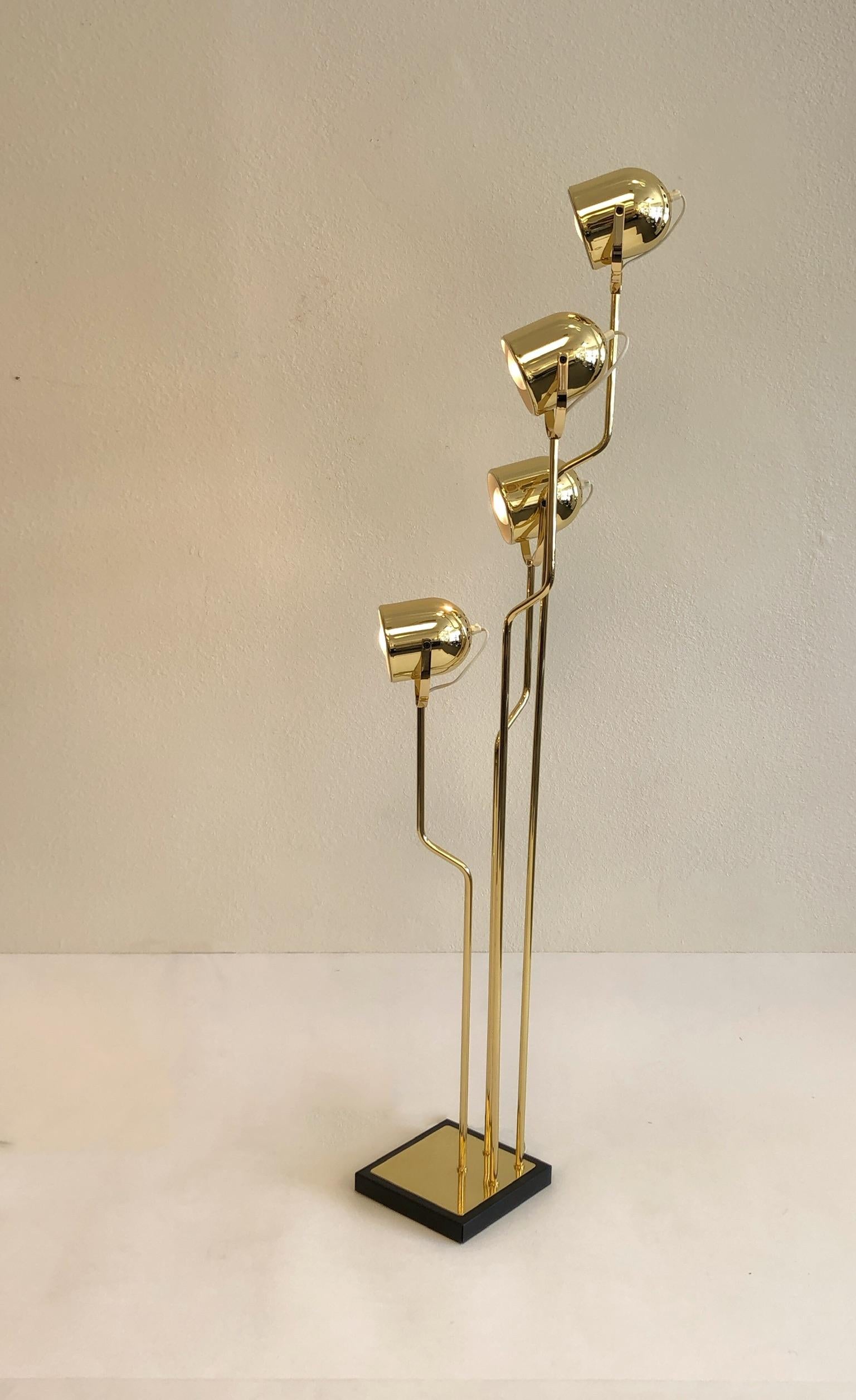 A beautiful Italian polish brass floor lamp with a black powder coated base, design in the 1970s by Goffredo Reggiani. The lamp has been professionally polished and lacquered. The four spot lights are adjustable. The lamp retains original