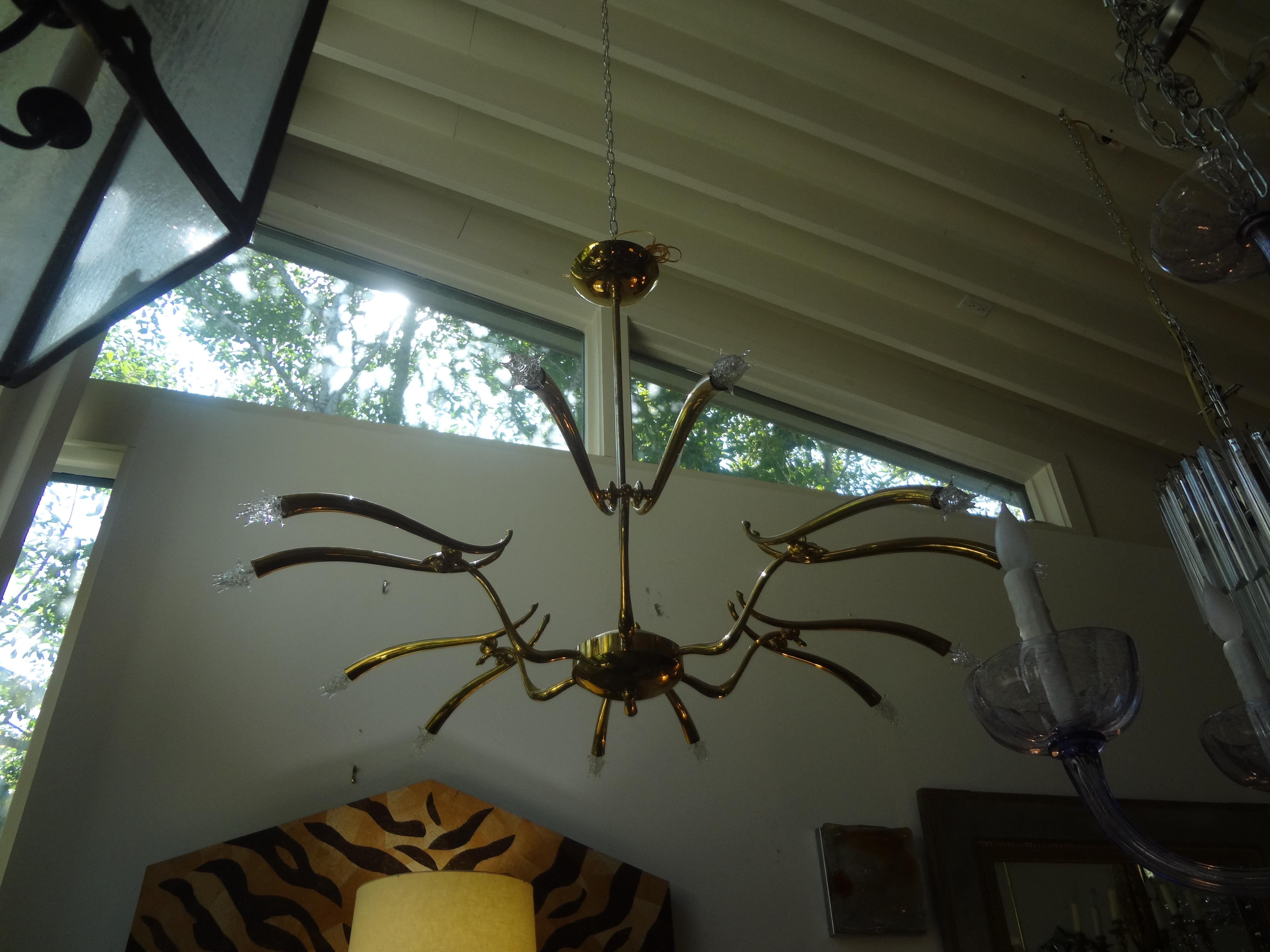 Fantastic Italian Mid-Century Modern polished brass 12-light Sputnik style chandelier attributed to Oscar Torlasco. This stunning Italian midcentury or Italian Futurist brass chandelier has been newly wired to U.S. specifications with new candelabra