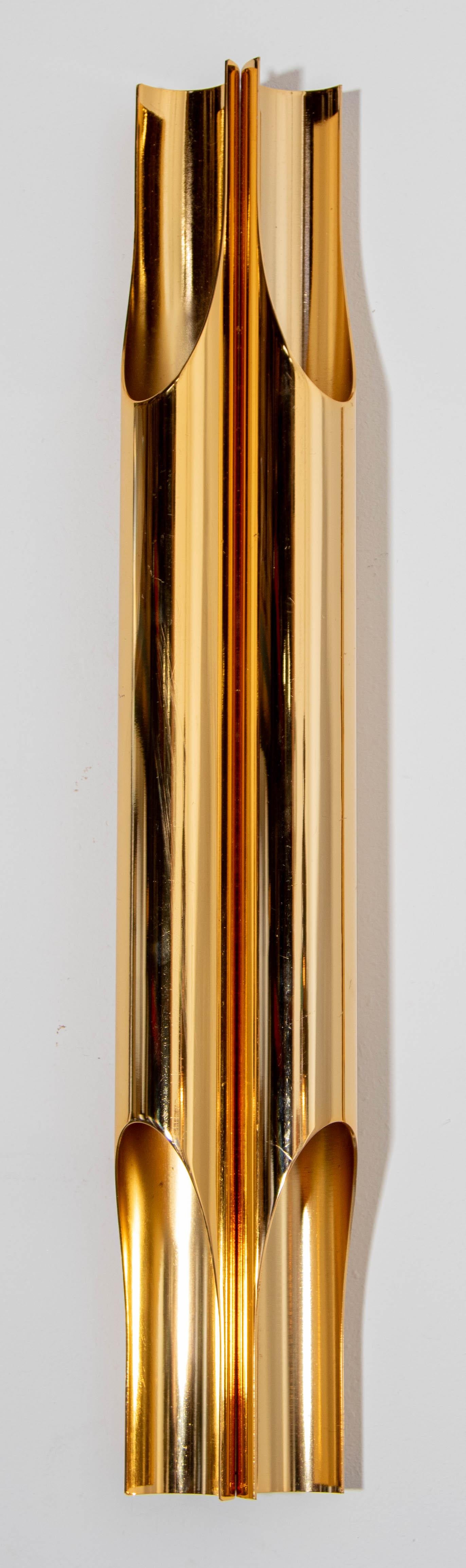 Exquisite and sophisticated, this Italian 'orgue' wall sconce boasts a polished brass finish. The interconnected pipes, crafted from polished brass metal, emit four radiant beams of light in opposing directions, offering a captivating glimpse of the