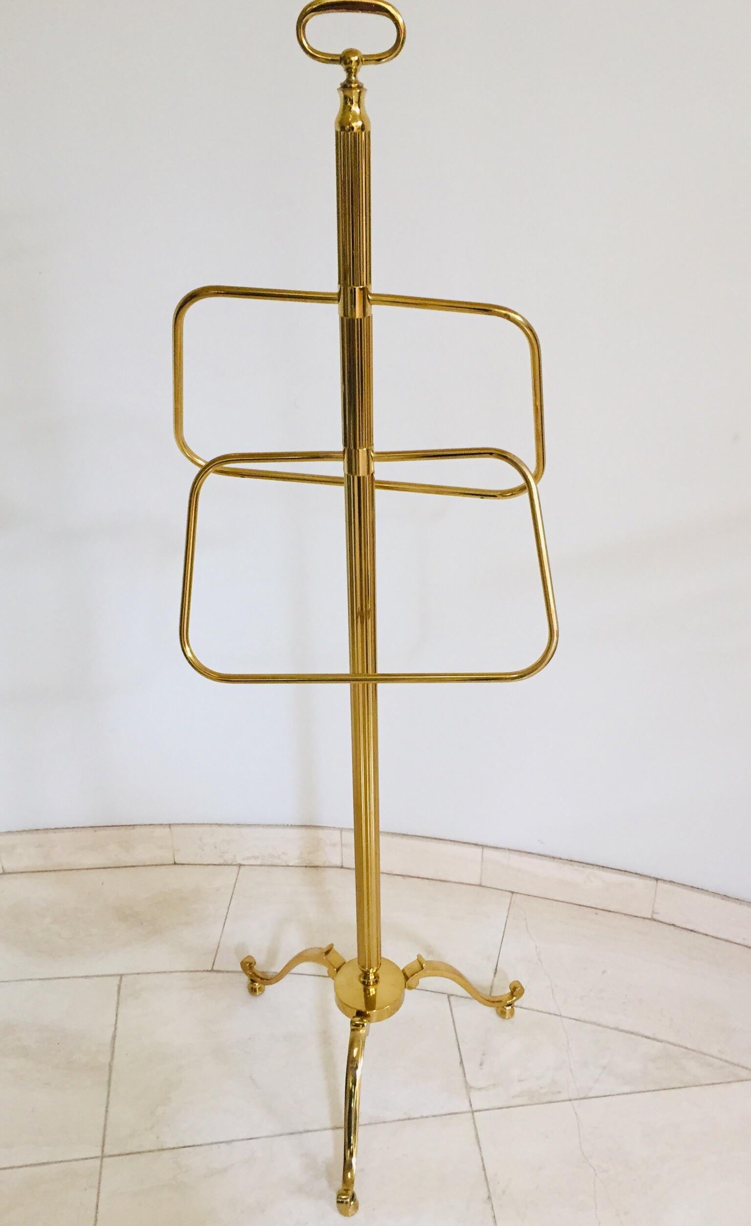 Stylish Italian polished brass glamorous valet stand.
A super elegant brass valet on tripod base with brass caster wheels. 
Marked 'Made in Italy', the piece is attributed to Maison Jansen.
Impressive Master craft Post Modern polished brass valet