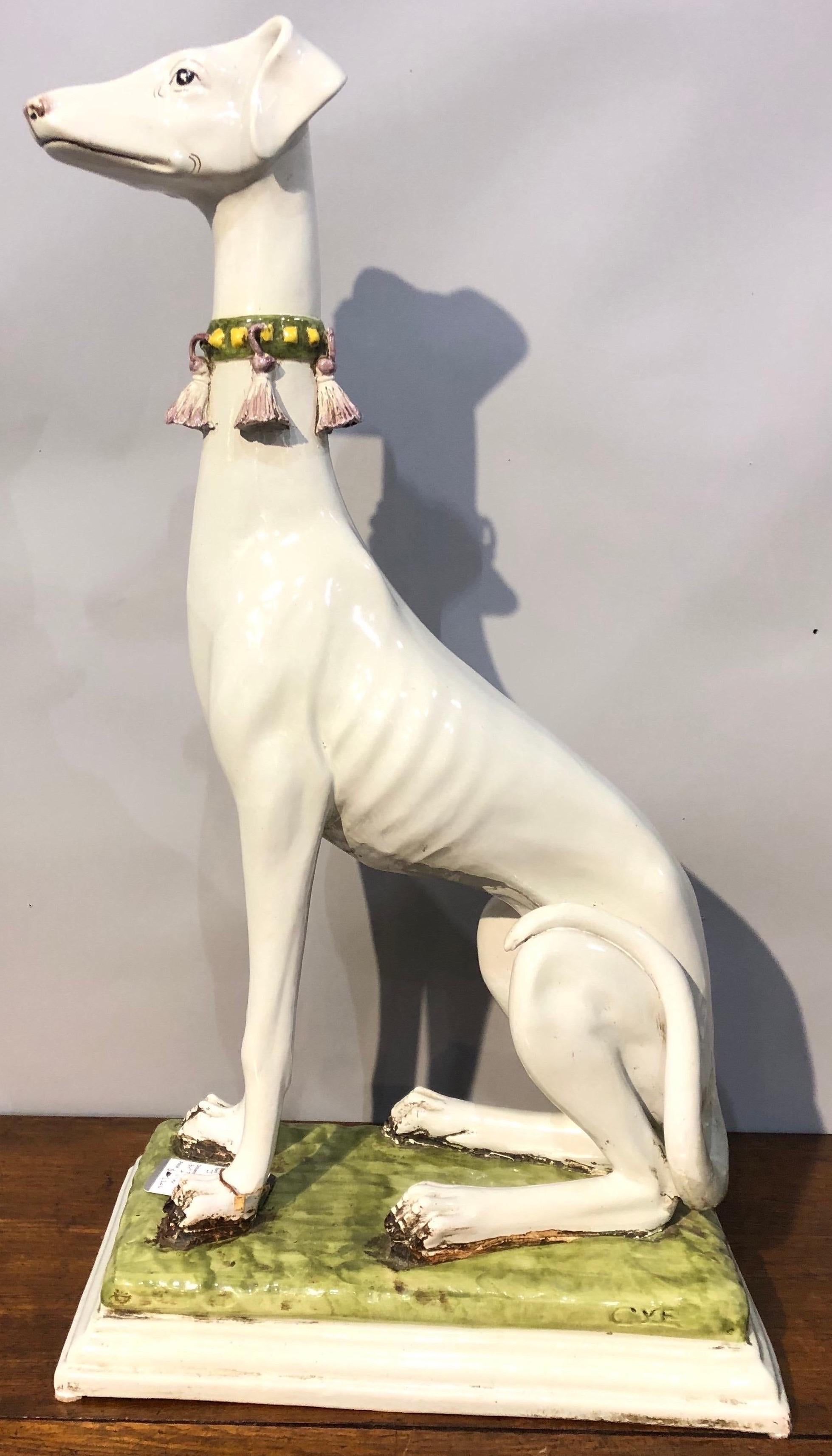 Italian polychrome ceramic greyhound with a tassel collar and green base

Stamped 