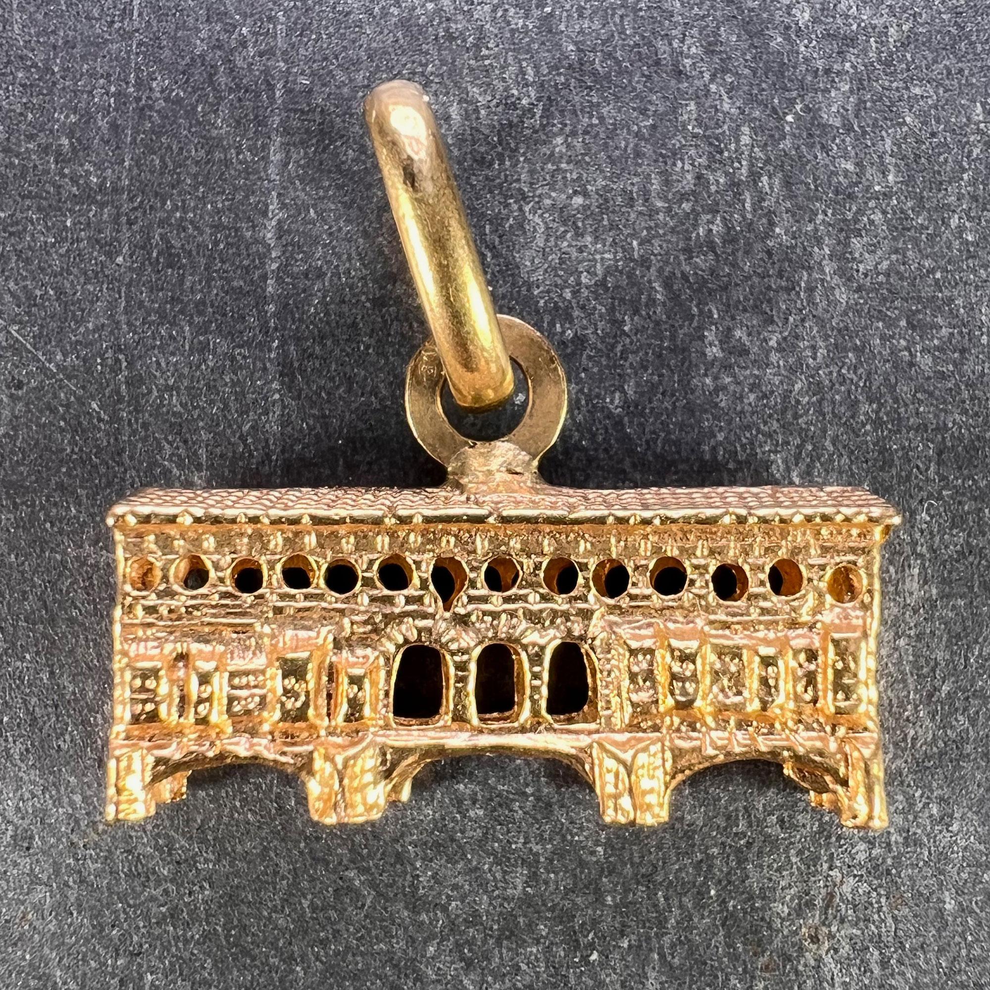 An Italian 18 karat (18K) gold charm pendant designed as the Ponte Vecchio Bridge in Florence, Italy. Marked 750 for 18 karat gold with the Italian maker's mark 247VI for Domenico Ganazzin, and stamped with the French import mark for 18 karat