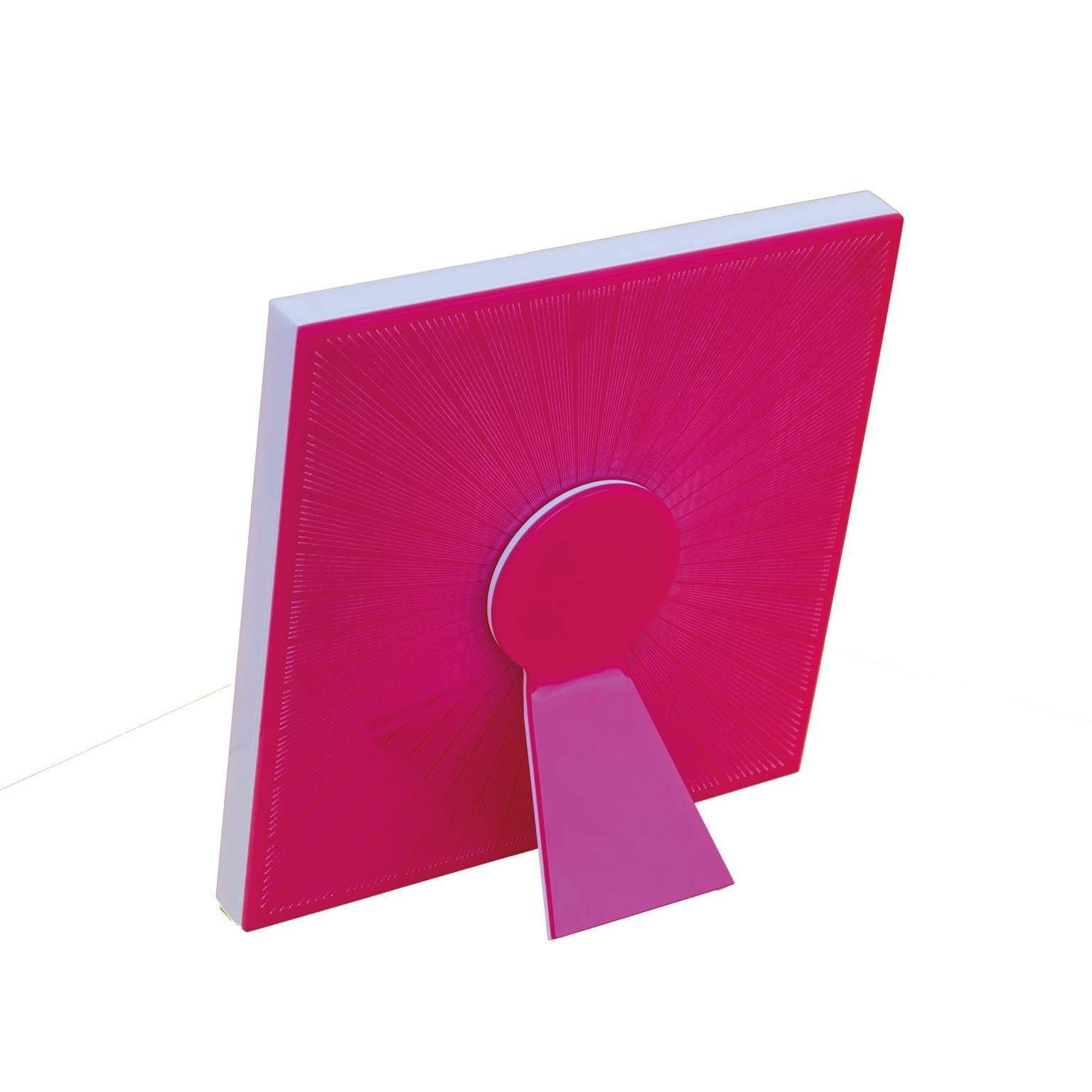 Sharing Shocking is a photo frame of Laura G Art with Heart collection of recto-verso photo frames. It is realized in shocking pink and white artistic plexiglass, with guillochè rays hand worked into shocking pink flou plexi, giving light to the