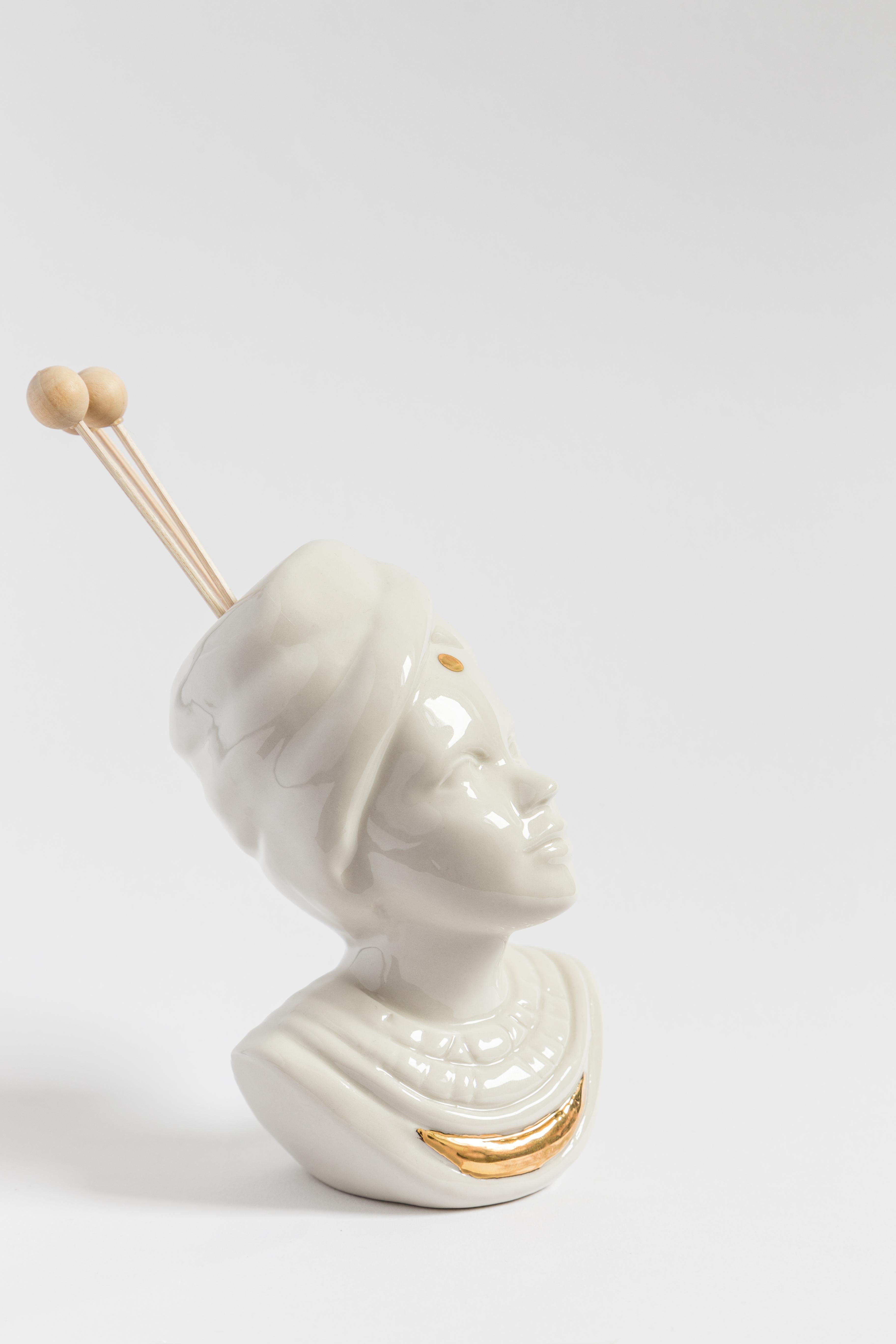 This Italian porcelain sculpture is part of Grand Tour by Vito Nesta. Made in Capodimonte porcelain with a glossy finish and gold detail, this sculpture is an essential oil diffuser and is shaped like an Indian woman.