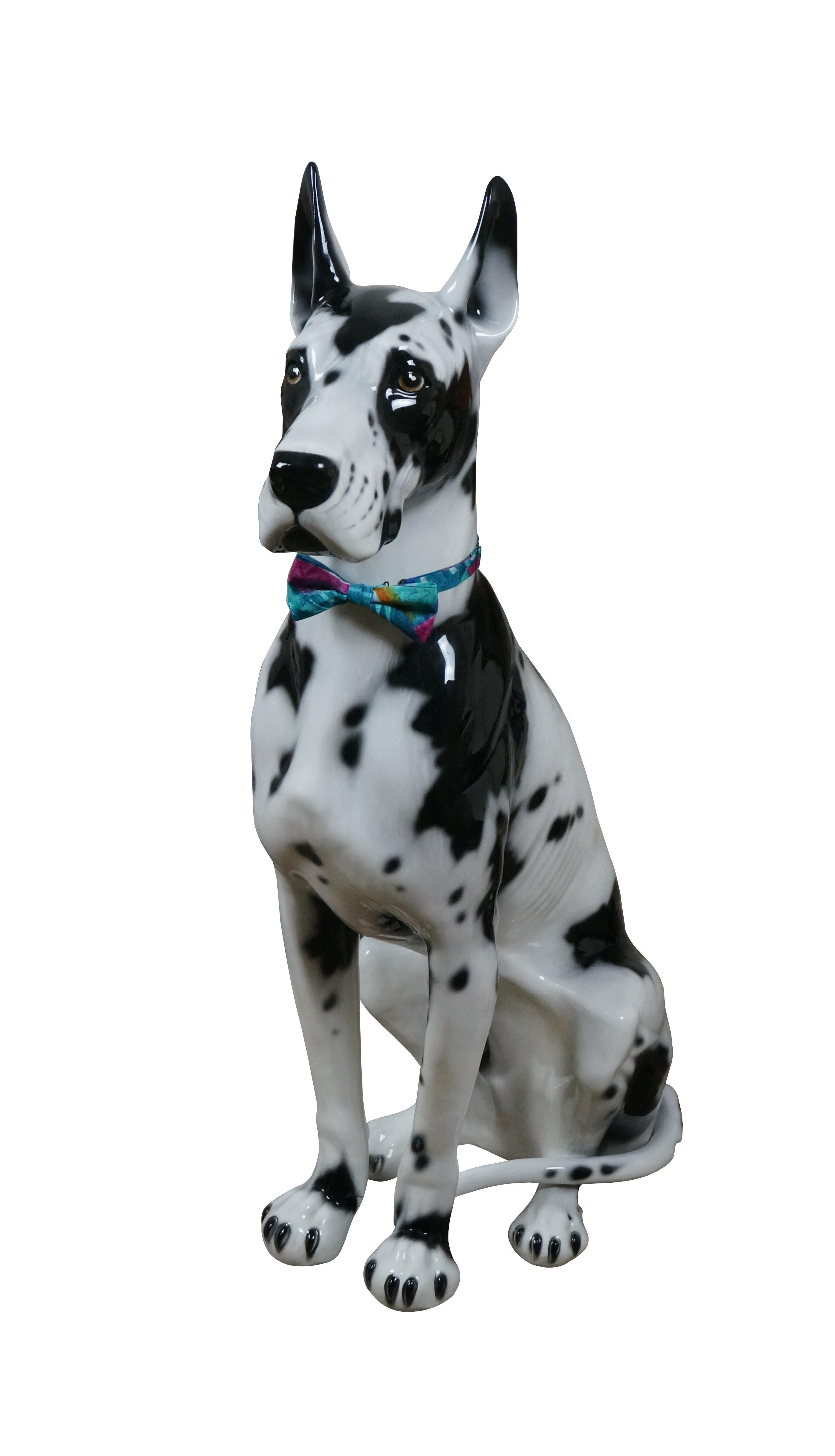 Intrada early 21st century life sized ceramic porcelain sculpture in the shape of a seated, black and white spotted Harlequin Great Dane. Made in Italy. Includes a fun and stylish 90's style bowtie. Discontinued, Intrada ANI1256

Dimensions:
19