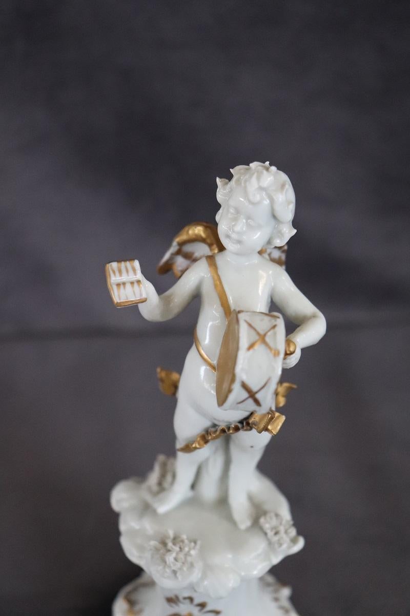 Beautiful musician angel in fine porcelain by Capodimonte, circa 1980s. White color with golden details. Refined collectible ornament. Brand present at the base. 