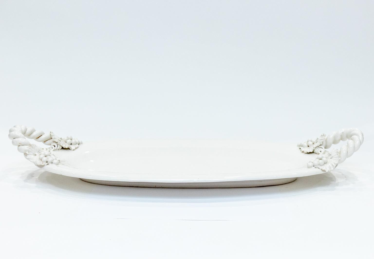 Oval form white porcelain platter featuring role twist design handles with applied floral sprays. Made in Italy. Please note wear consistent with age.
 