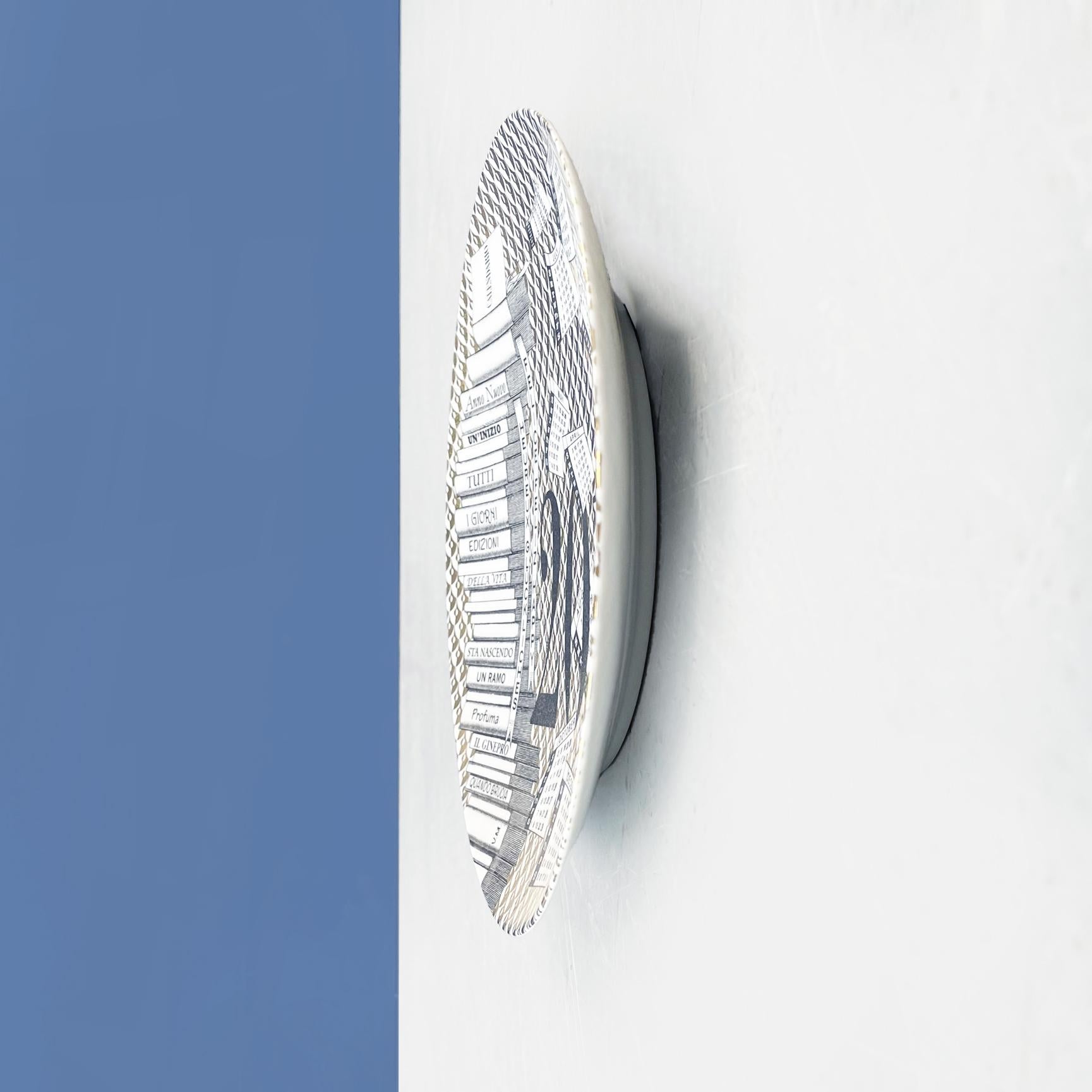 Italian post-modern ceramic wall calendar plate 2016 by Fornasetti, 2016.
Wall calendar plate of 2016, limited edition, in ceramic. It present a drawing of a stack of books, with flying fishes and boats, in black and white with golden