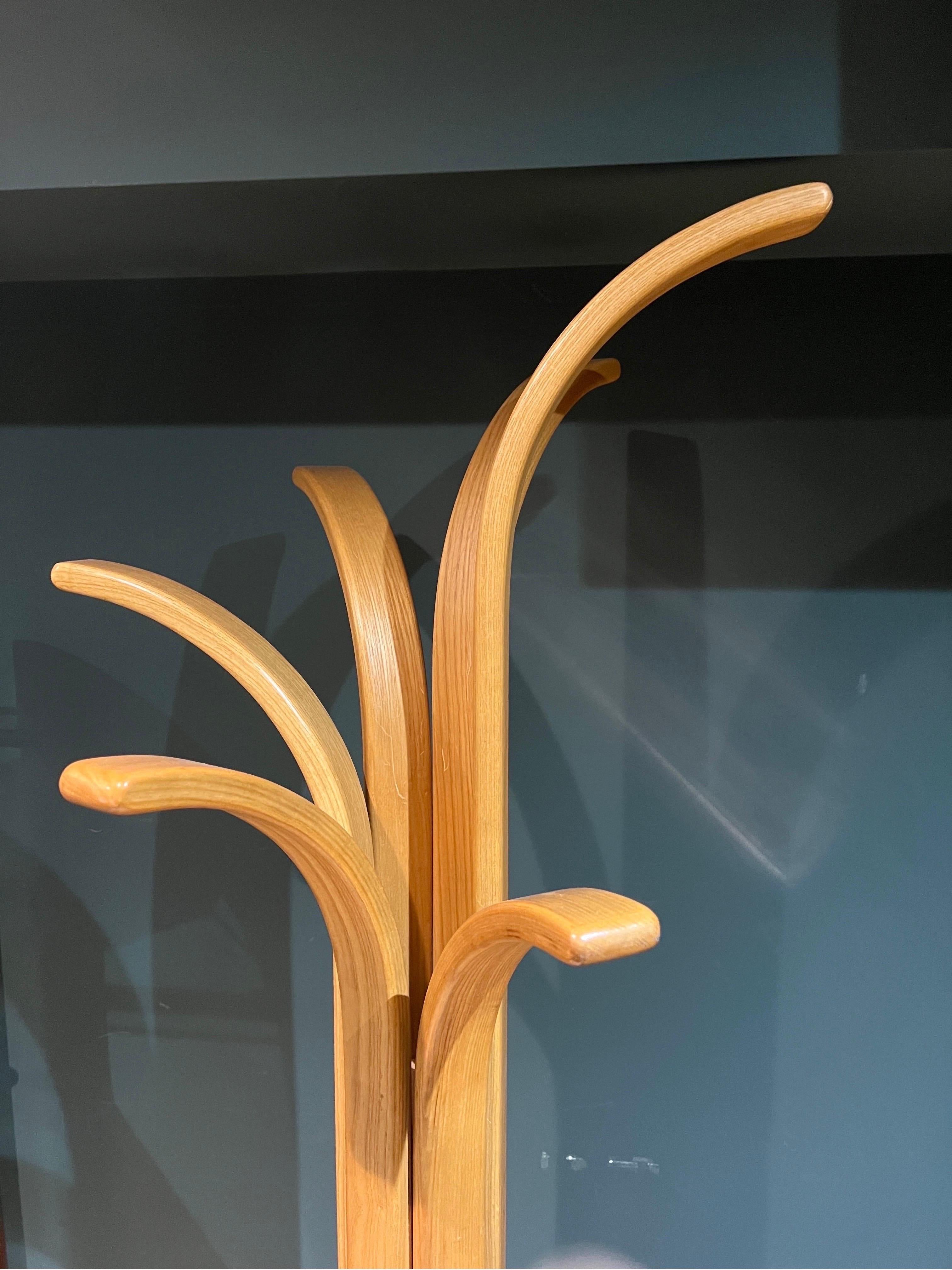 A sculptural post modern coat stand in natural polished plywood with travertine base 
Italy C1970 