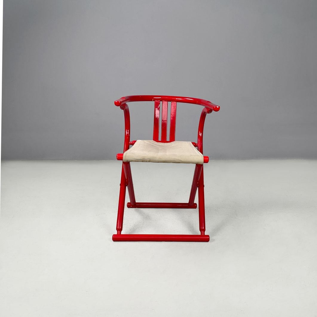 Italian post-modern folding tub chair in red wood and beige fabric, 1980s
Folding cockpit chair with red painted wooden frame. The frame has a round section, and comprises the enveloping backrest and crossed 