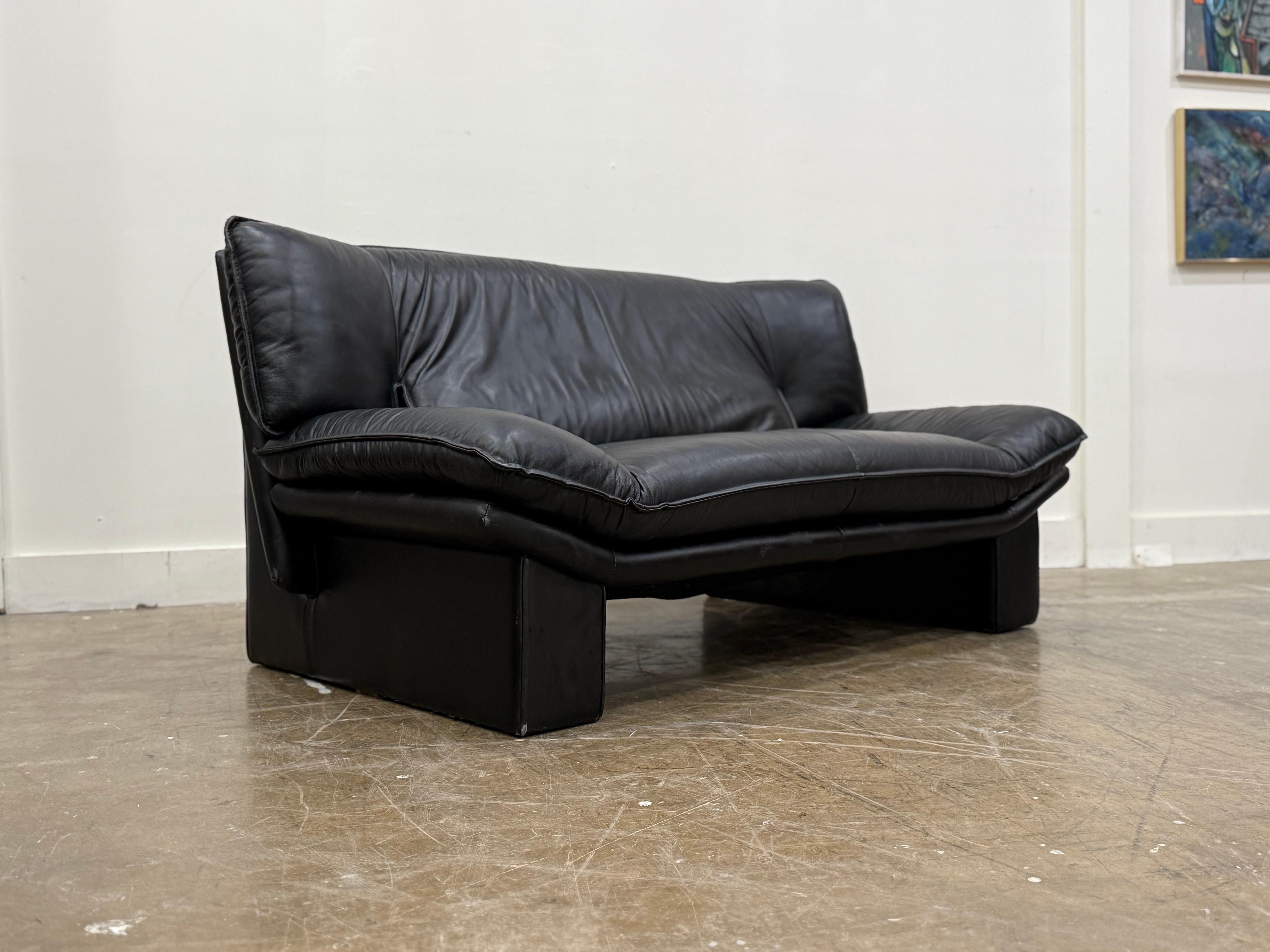 Stellar post modern loveseat sofa by Nicoletti Salotti, Italy circa 1980s. Finely appointed and fully dressed in high grade top grain black Italian leather. Striking and stark angular lines for a stunning silhouette. Attended to by our team of in