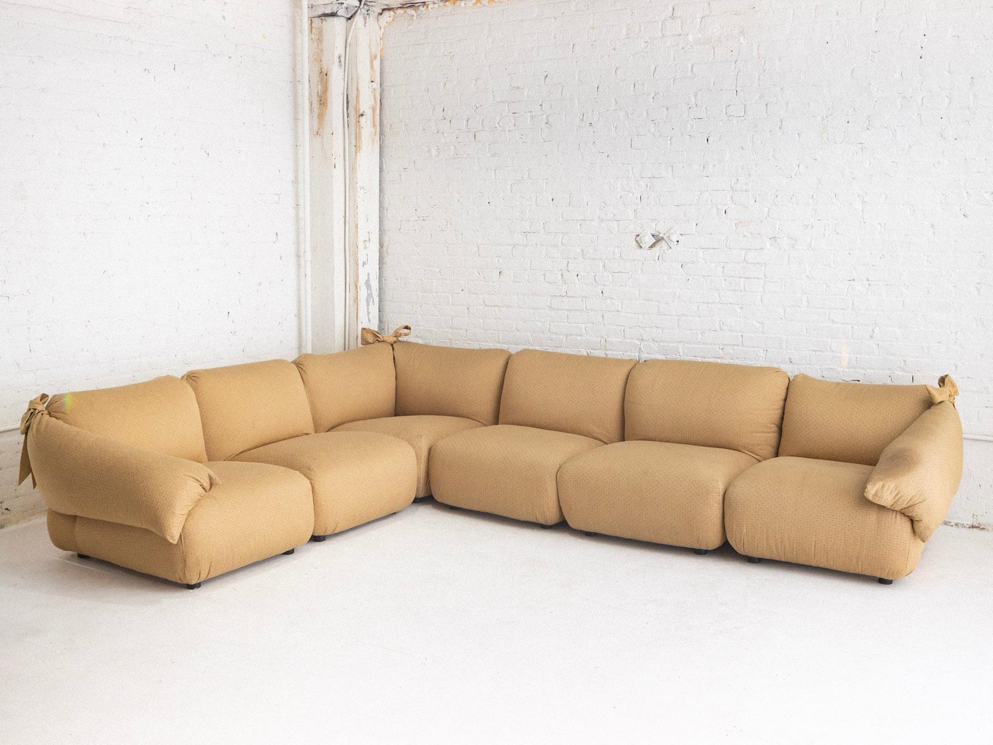 A 6 piece post modern Italian sectional. Overstuffed silhouette with tied bow detail at the corners. Original beige upholstery as found. Reupholstery recommended. Sourced in Rome, Italy.

Additional Measurements:
Interior Corner Piece: 35” wide, 35”