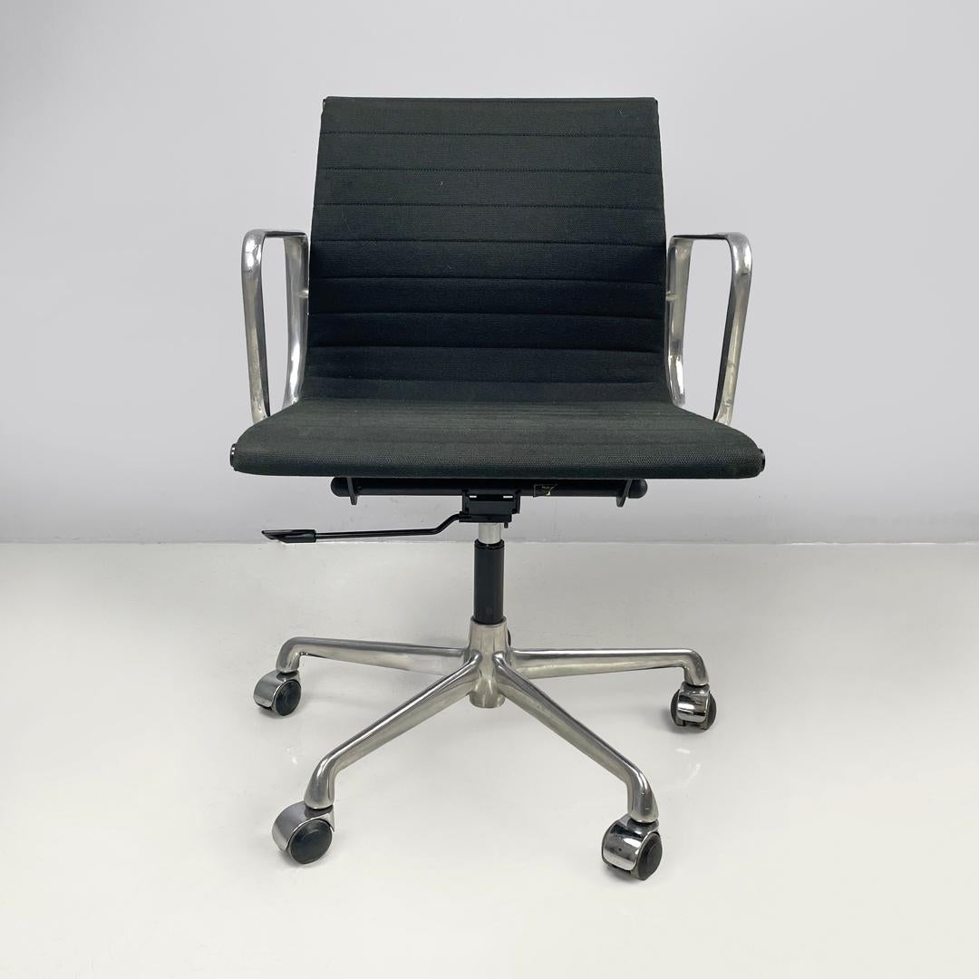 Italian post modern office chair EA108 by Charles and Ray Eames for ICF, 2000s 
Swivel office chair with wheels and armrests. The seat and backrest are covered in dark forest green fabric. The central stem is in black plastic, the chair has five