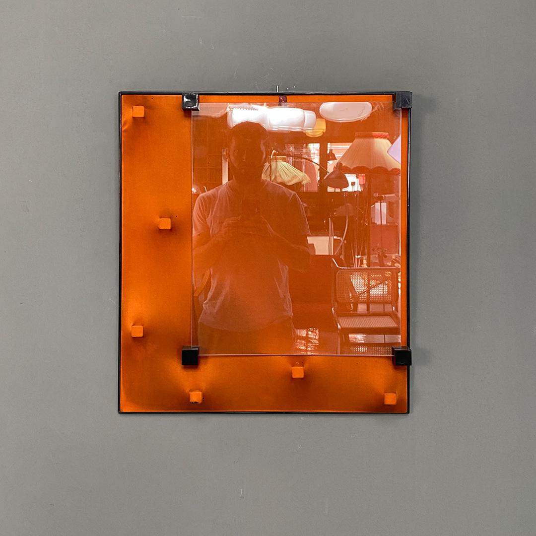 Italian post modern orange plastic and glass wall photo frame, 1980s.
Photo frame with plastic structure with four supports that hold the two thin glasses, inside which the photos are inserted.
Orange background, in canvas, with various holes