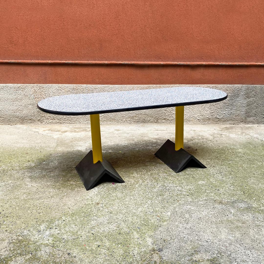 Italian post modern rubber, metal and laminate oval table with bacterio texture, Memphis style, 1980s.
Oval table with double yellow metal pedestal, with black rubber bases and top with black edge and new formica piano with bacterio pattern,