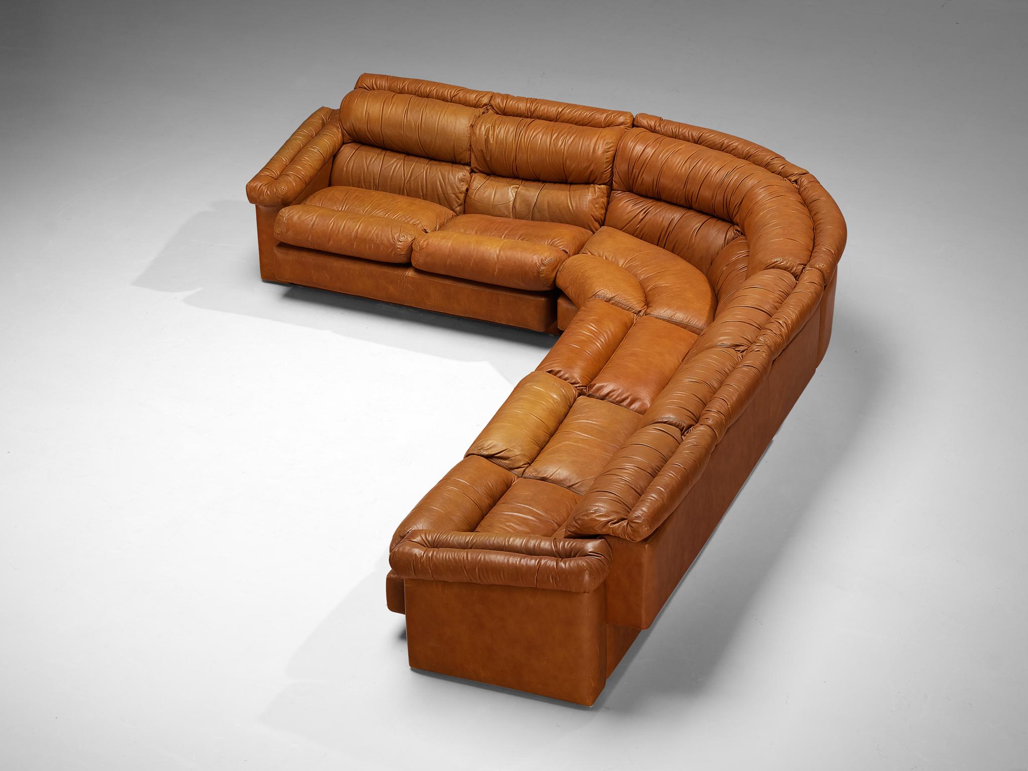 Modulares Ecksofa, Leder, Italien, 1970er Jahre

Ein geräumiges italienisches Ecksofa in L-Form, gepolstert mit festem cognacfarbenem Leder. Die Kissen sind großzügig gepolstert und haben ein abgerundetes, plüschiges Aussehen mit horizontalen