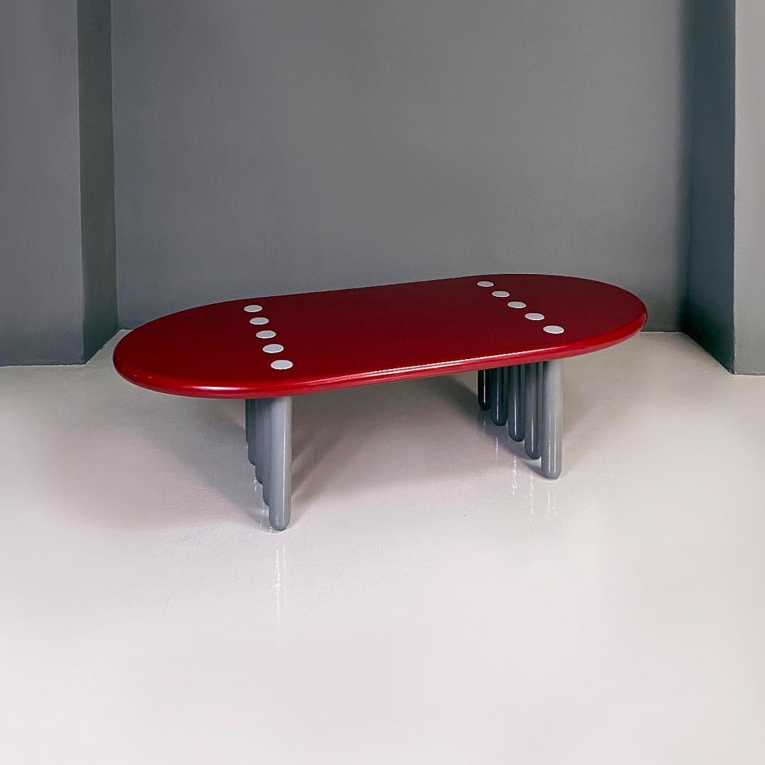 Italian post modern ten-legged lacquer bordeaux and grey wood coffee table, 1980s.
Ten-legged coffee table, with solid wood structure with brick red lacquer on the oval-shaped top and gray round section legs.
1980s.
Good condition, but numerous