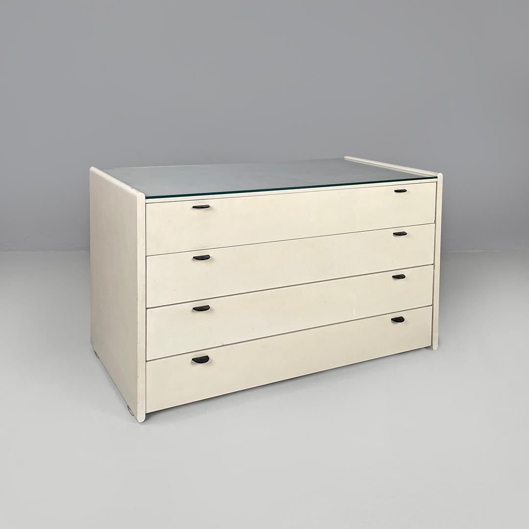 Italian post-modern white wood chest of drawers with black plastic handles 1980s
Rectangular chest of drawers in white painted wood. On the top there is a second transparent glass top, the four drawers have on each two semicircular black plastic