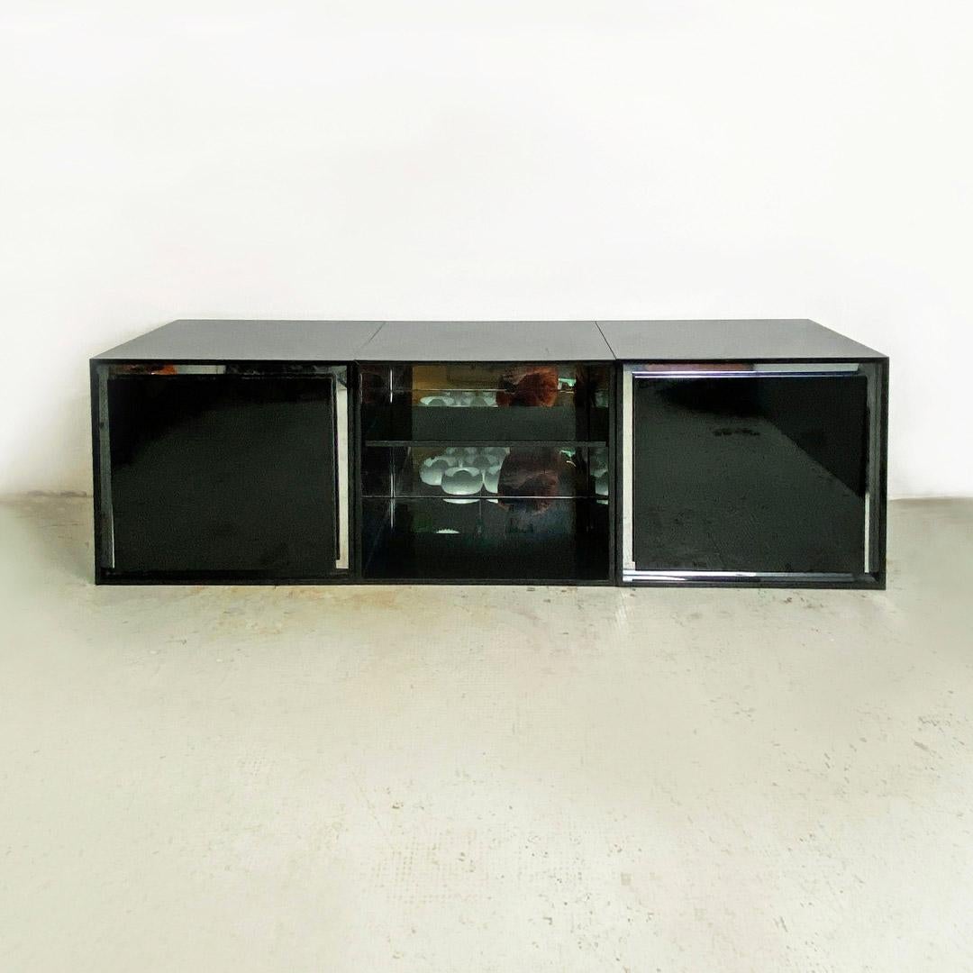 Italian post modern wood glossy black and mirrored modular sideboard, 1980s
Modular wood sideboard with glossy black finish and mirrored details, consisting of two twin modules with hinged door, with mirroring along the perimeter and internal shelf