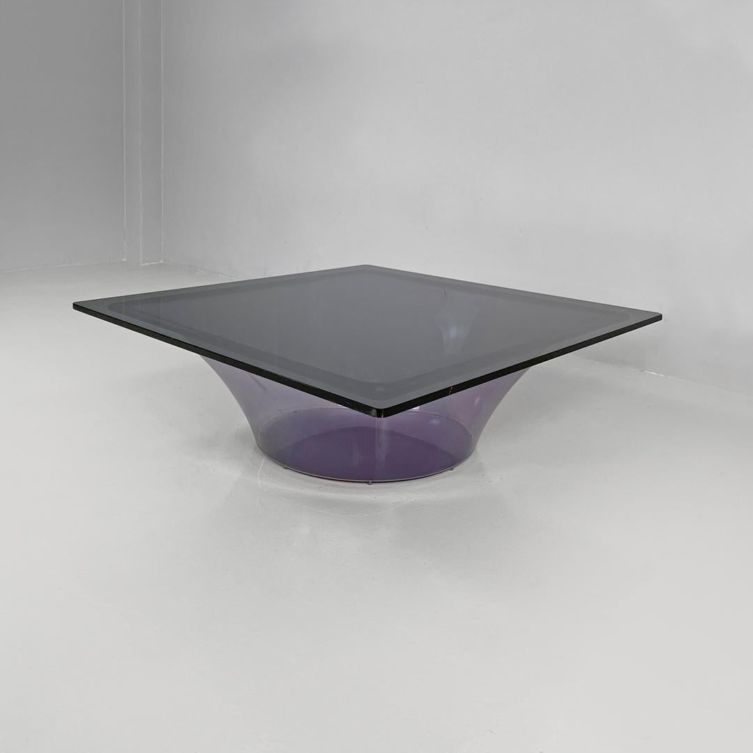 Table basse moderne italienne en plexiglas violet et verre fumé, 1970
Table basse à base ronde. Le plateau est carré en verre fumé gris foncé, tandis que la structure porteuse est en plexiglas violet semi-transparent et présente une forme évasée,
