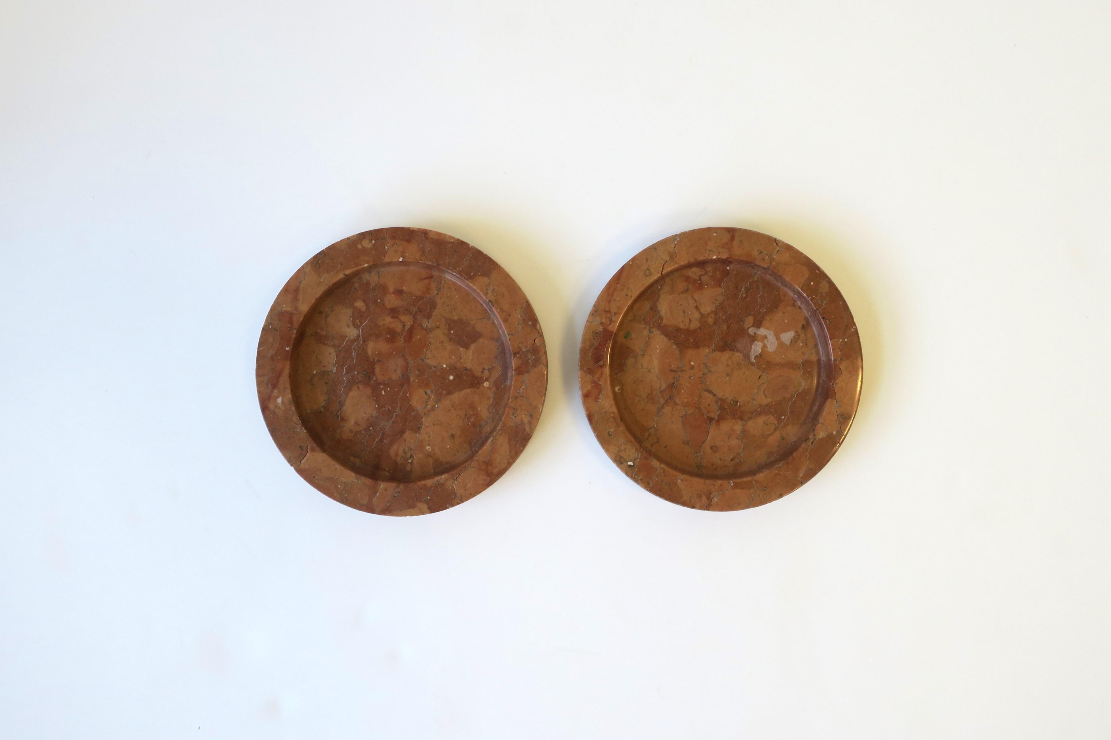 A set of two (2) Italian Postmodern marble terracotta hue wine bottle table coasters, circa late-20th century, Italy. A substantial pair of marble wine or water bottle table coasters. Hue is terracotta. Pieces could also be used as a jewelry or desk