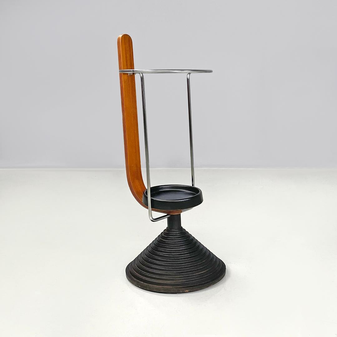 Italian postmodern round umbrella stand by Origlia in cast iron and wood, 1980s
Round umbrella stand, with round chromed metal rod structure and a rounded wooden strip. The plate at the base of the structure is made of black synthetic material. The