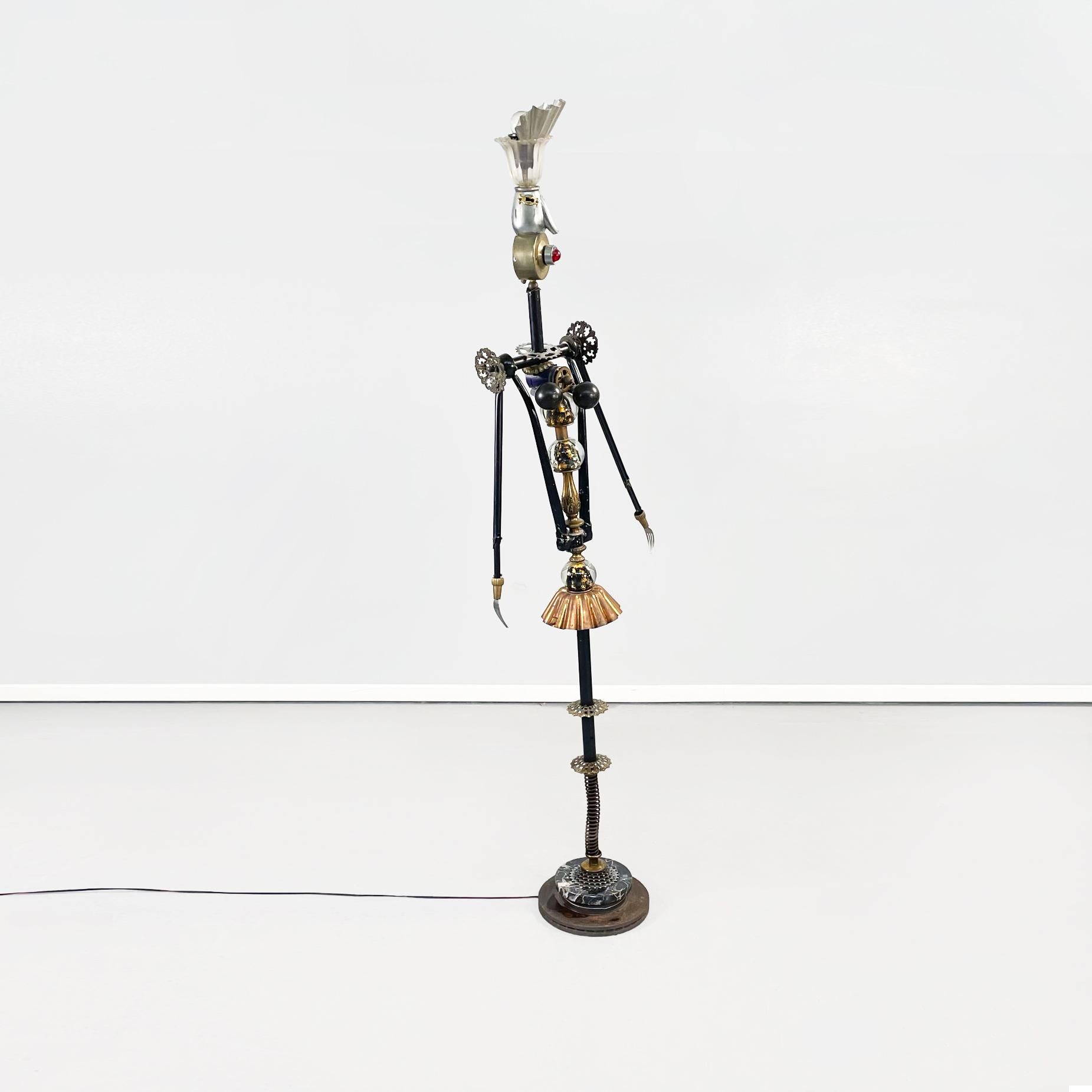 Italian postmodern Sculptures and floor lamps in metal, glass and marble, 2000s
Pair of sculptures and floor lamps with a humanoid shape, in metal, brass, dark marble and glass. These lamps have two lights, one of which is red, both placed at head