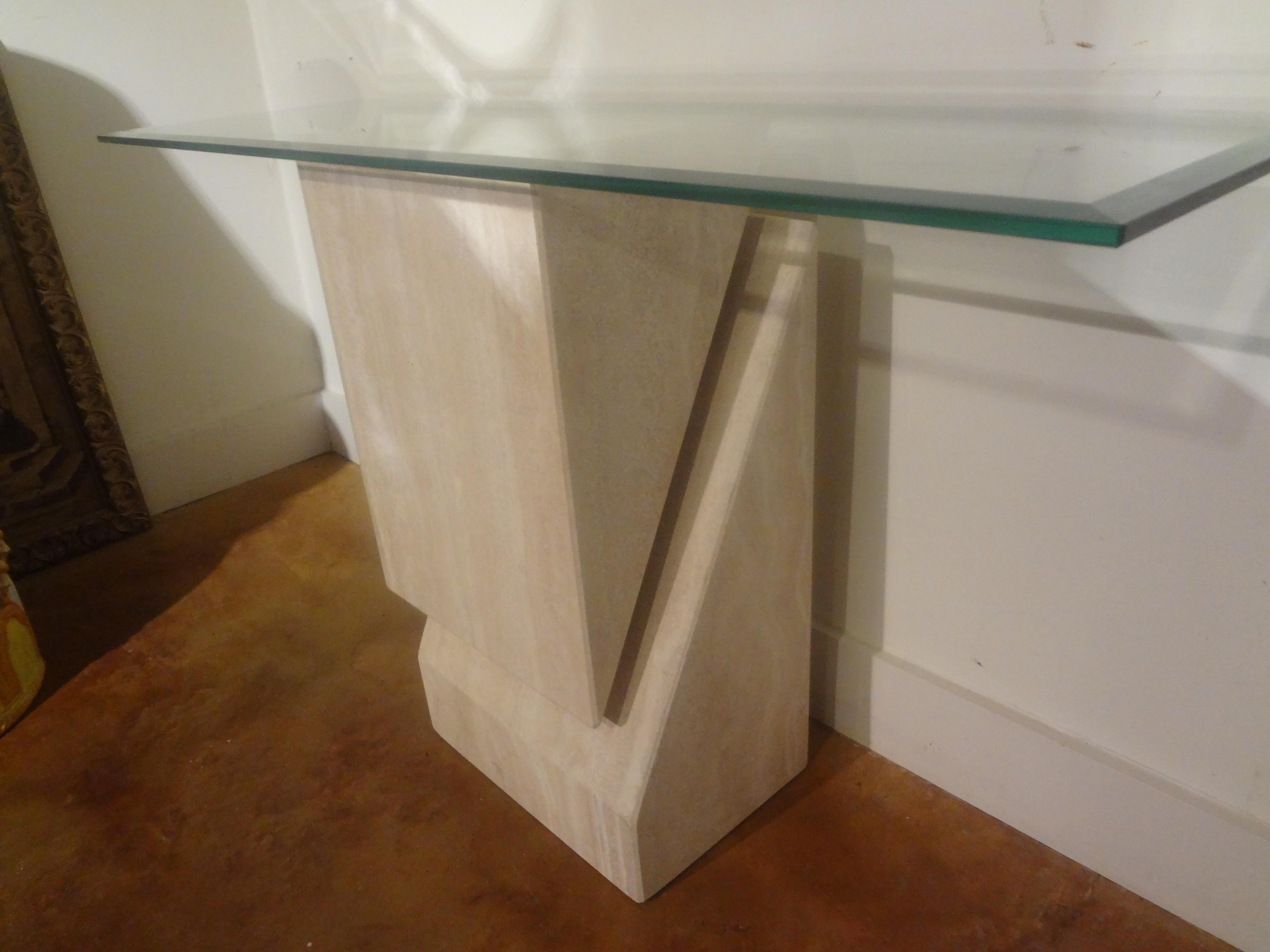 Italian Modernist Travertine Console Attributed To Angelo Mangiarotti.
This stunning Italian Postmodern honed travertine console table is beautifully designed with a beveled glass top. This versatile table that can be used in an entrance hall,